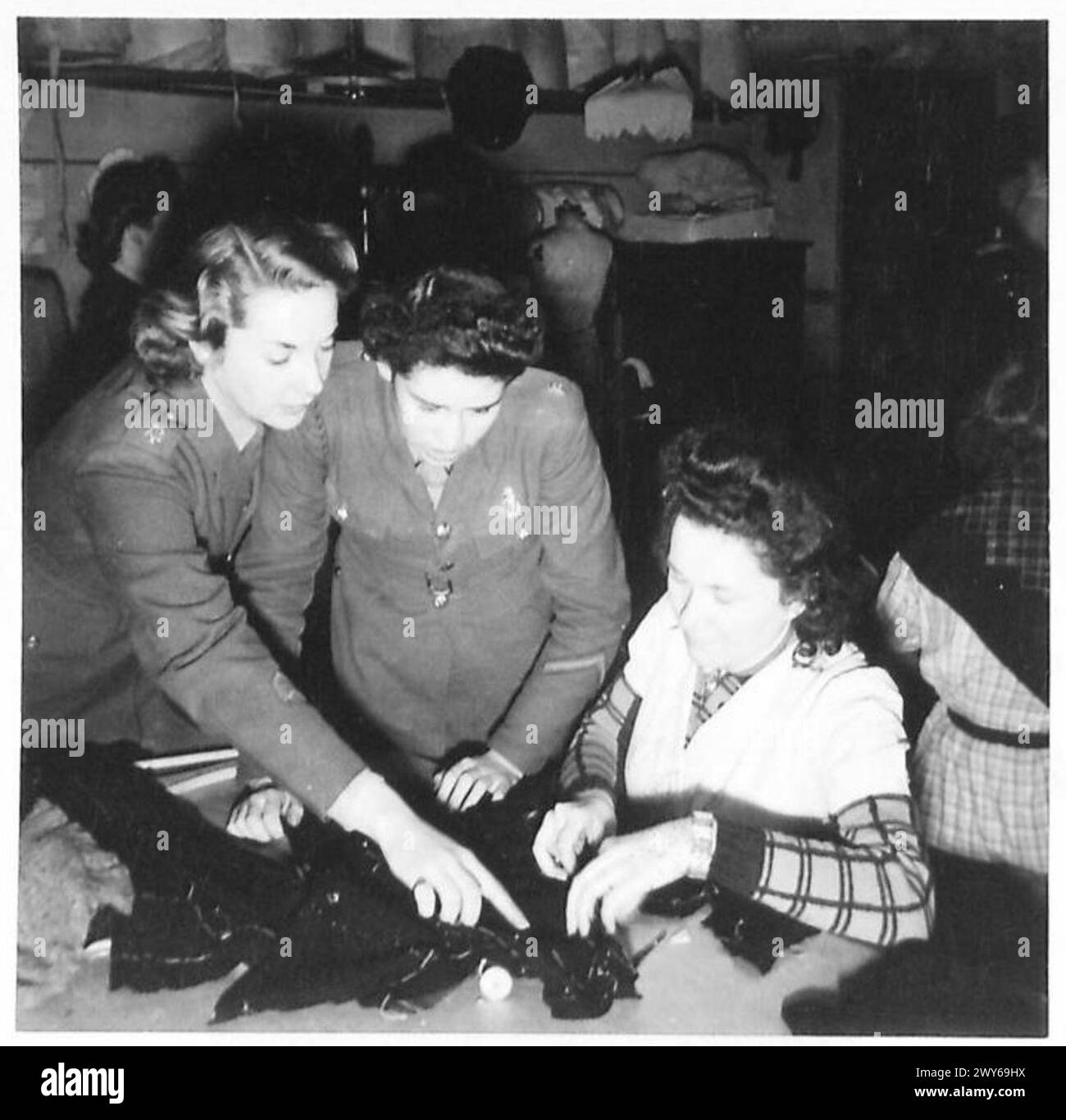 Die Private Joyce Wiltshire aus London und Terry Dawson aus Sheffield sprechen mit einer Midinette auf einer Pariser Modenschau. Britische Armee, 21. Armeegruppe anwesend. Stockfoto