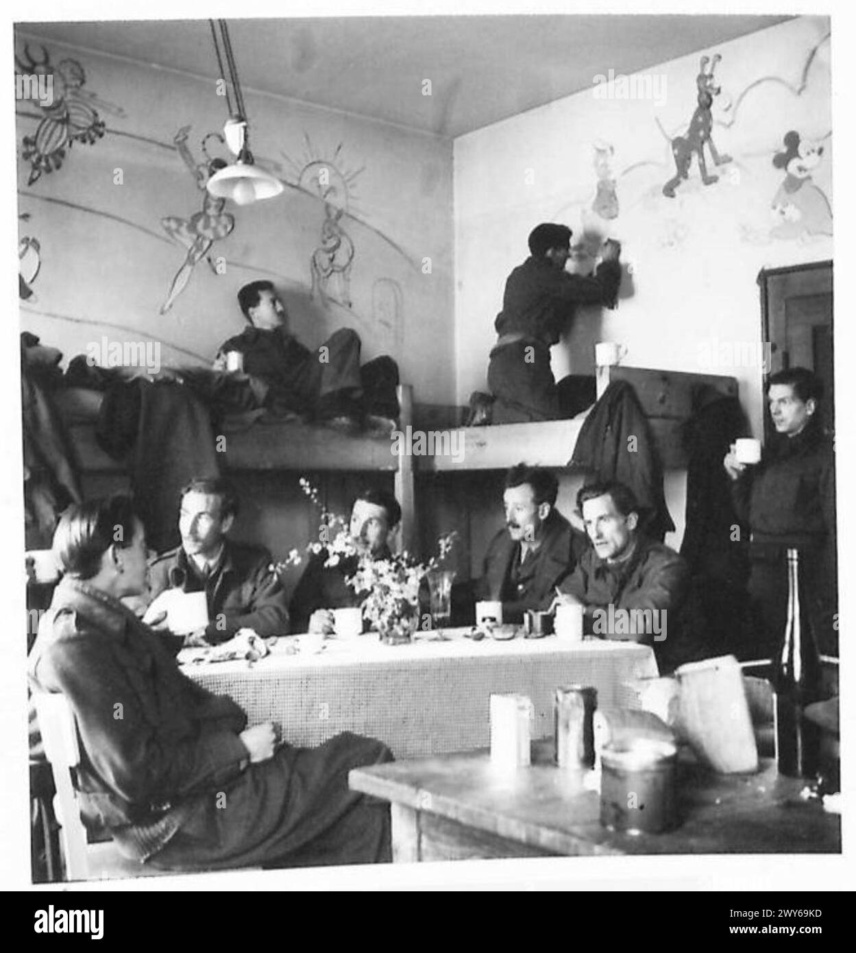 Eine allgemeine Ansicht eines Wohnzimmers bei Oflag 79 in Braunschweig zeigt zwölf mit Zeichnungen verzierte Offiziere mit Wänden, dokumentiert von der britischen Armee, 21st Army Group. Stockfoto