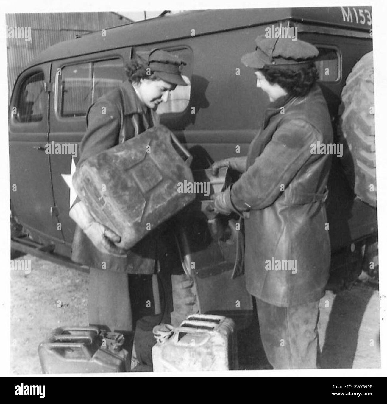 Der Private R. Norman aus Ilford und die Private Helen Shaw aus Newcastle füllten Benzintanks an einer Tankstelle; beide landeten in der Normandie während der frühen Phase des Feldzugs in Frankreich unter Aufsicht der britischen Armee 21st Army Group. Stockfoto