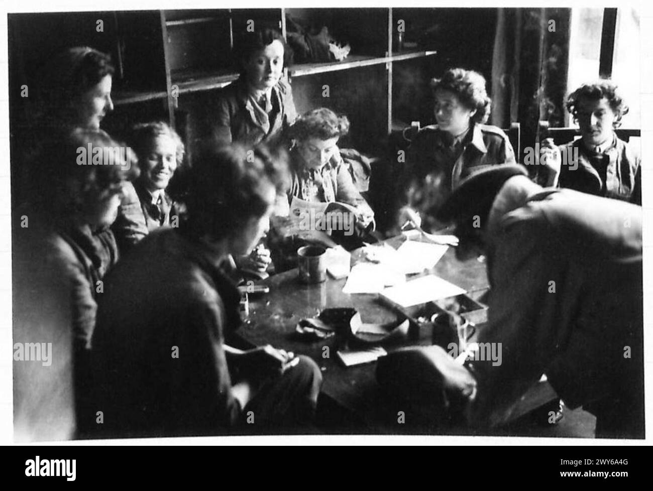 Die Mitglieder des örtlichen Hilfsdienstes in Brüssel machen nach der Fahrzeugwartung in ihrem Aufenthaltsraum eine Mittagspause mit Tee und Zigaretten. Stockfoto