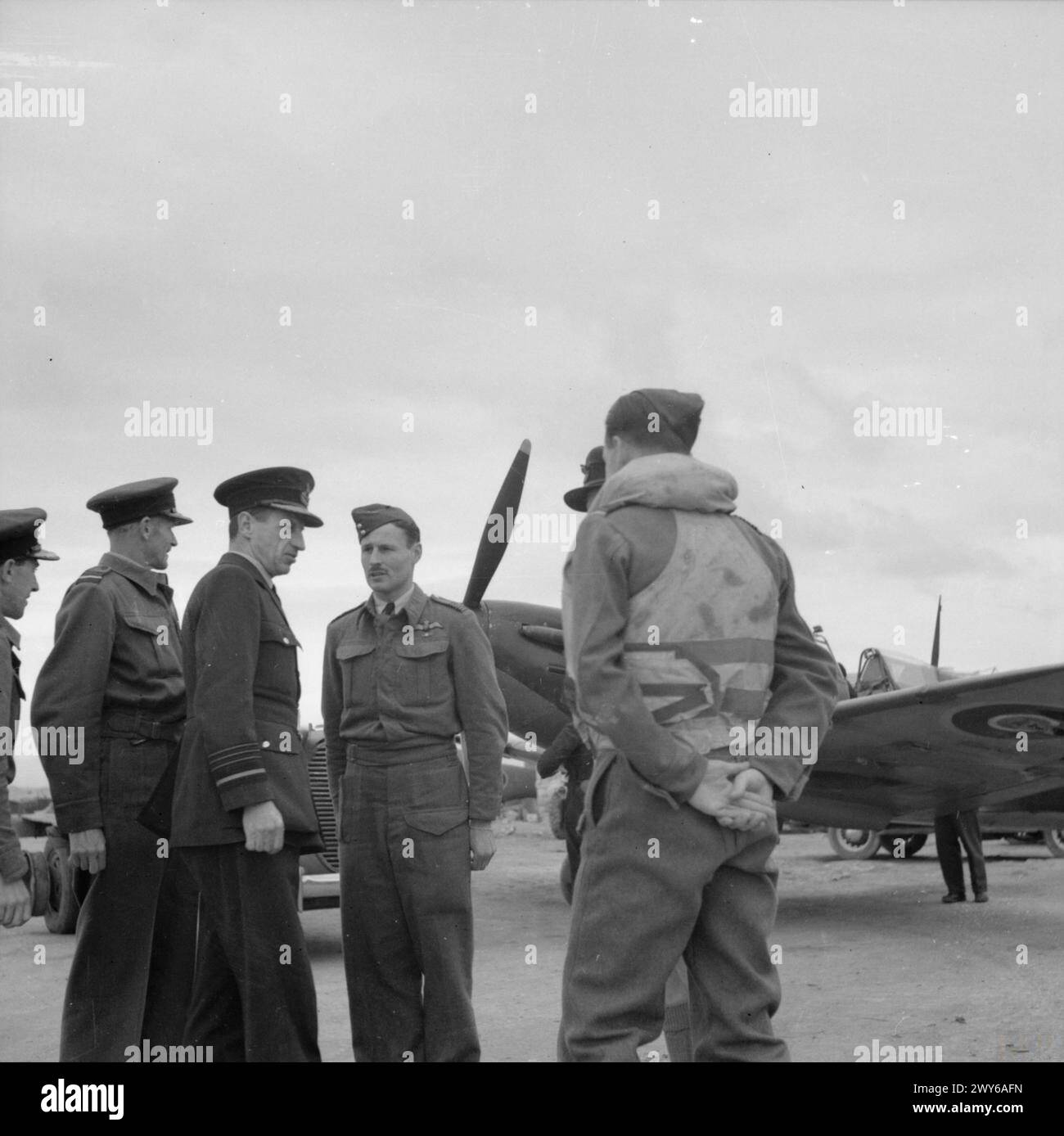 KÖNIGLICHE LUFTWAFFE IN MALTA, GIBRALTAR UND DEM MITTELMEER, 1940-1945. - Air Chief Marshal Sir Charles Portal, Chief of the Air Staff (dritte links), begleitet vom Air Officer der RAF Malta, Air Vice-Marshal Sir Keith Park (zweite links), im Gespräch mit Piloten des Luqa Fighter Wing, vor einem Supermarine Spitfire in einer Zerstreuung in Luqa, während seines Besuchs auf der Insel. Der vierte von links steht Wing Commander J M Thompson, Anführer des Luqa-Flügels. , Portal, Charles Frederick Algernon, Park, Keith Rodney Stockfoto