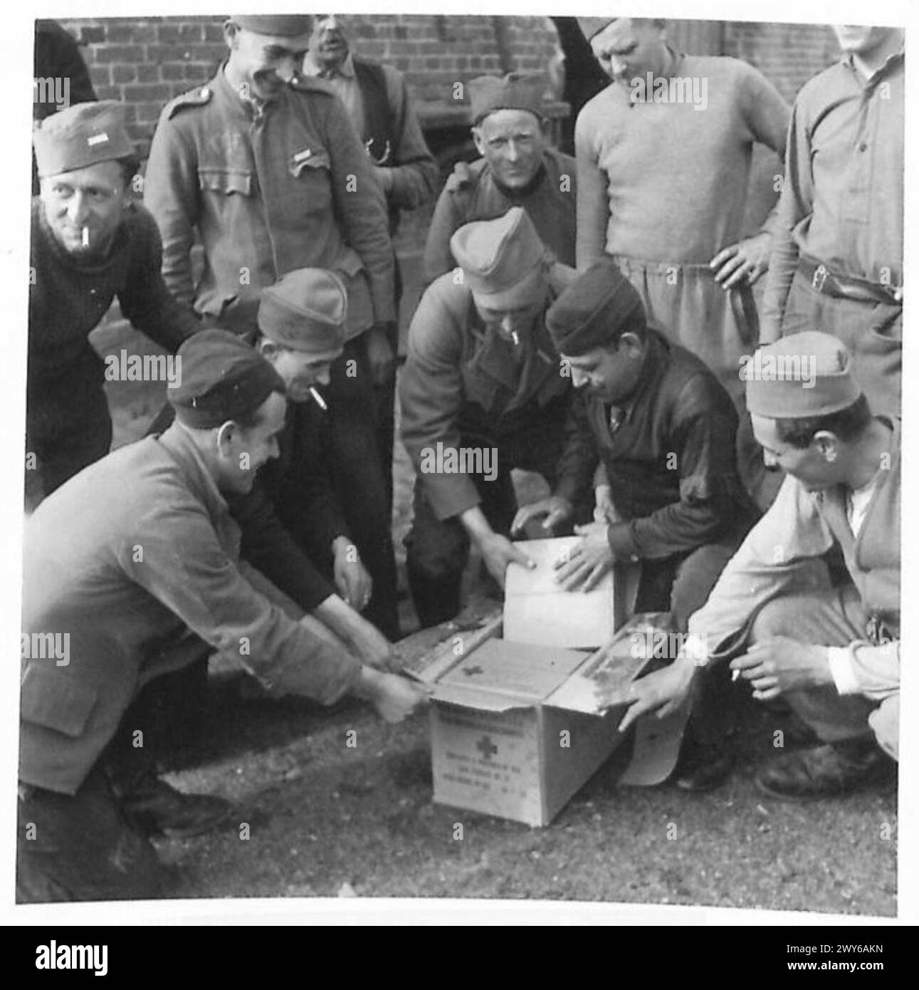 Jugoslawische Zivilisten versammeln sich, als Rote-Kreuz-Pakete von der britischen Armee, 21. Armeegruppe, während des Zweiten Weltkriegs verteilt und geöffnet werden Stockfoto