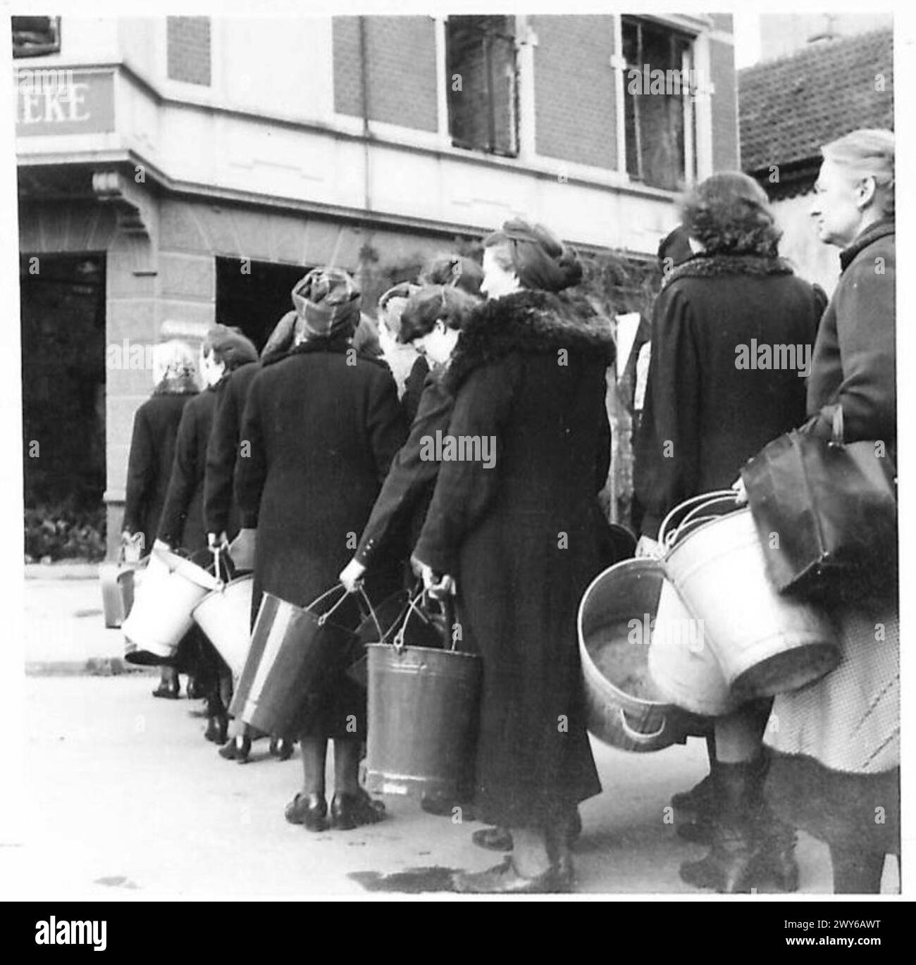 Deutsche Frauen stehen an einer Wasserpumpe in Bremen an und veranschaulichen das tägliche Leben und die Sammlung von Ressourcen unter Nachkriegsbedingungen. Stockfoto