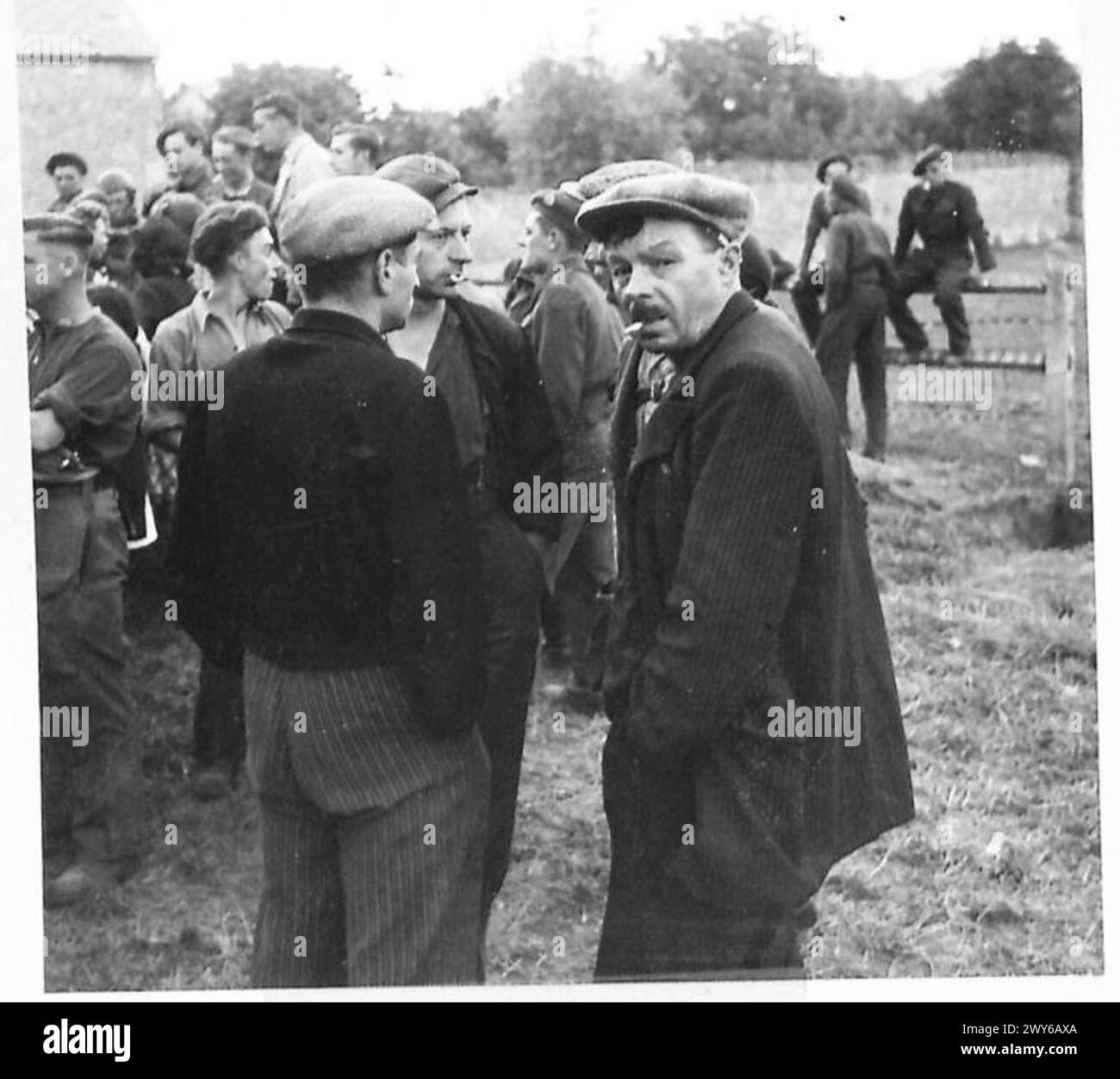 Französische Dorfbewohner diskutieren die jüngsten Nachrichten nach der Befreiung und veranschaulichen das zivile Leben der Nachkriegszeit und den Informationsaustausch. Stockfoto