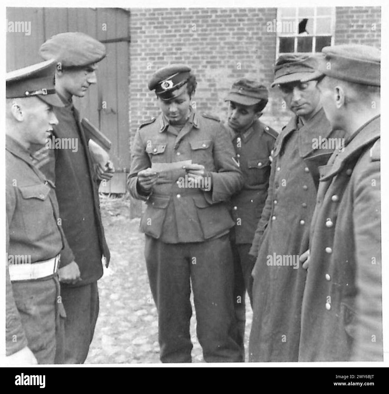 BRITISCHE TRUPPEN DRINGEN IN HAMBURG EIN – Gefangene, die sich am Stadtrand von Hamburg aufgegeben hatten, werden Zeitungsausschnitte von Gräueltaten des KZ Belsen gezeigt. Britische Armee, 21. Armeegruppe Stockfoto