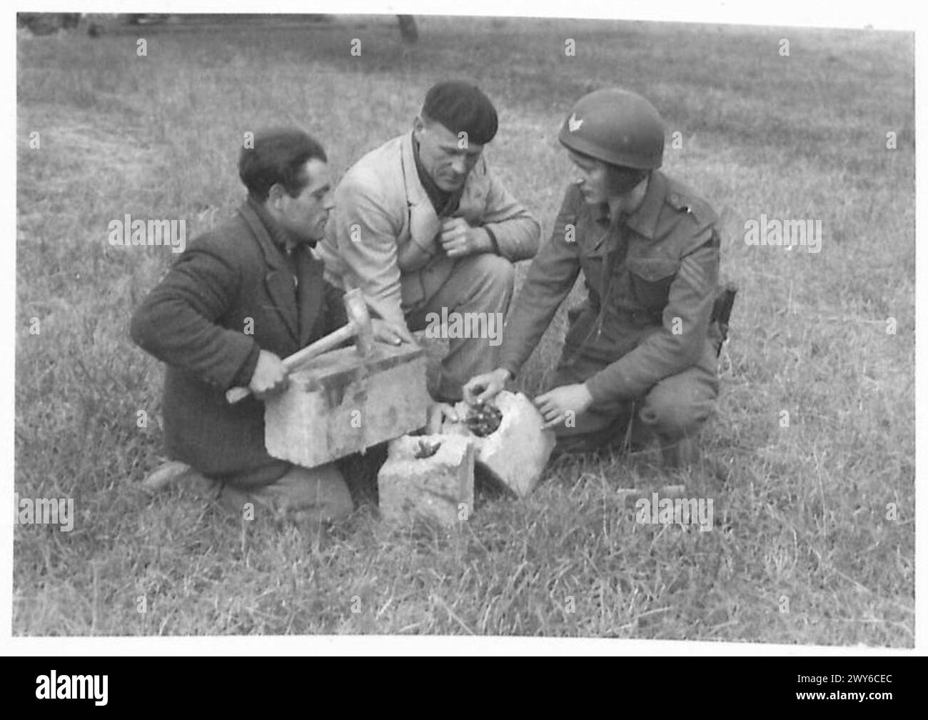 Marcel Doisy demonstriert einem Sergeant des Panzerkorps der 3. Division, wie Munition während der Widerstandsoperationen in Pflastersteinen versteckt wurde. Stockfoto