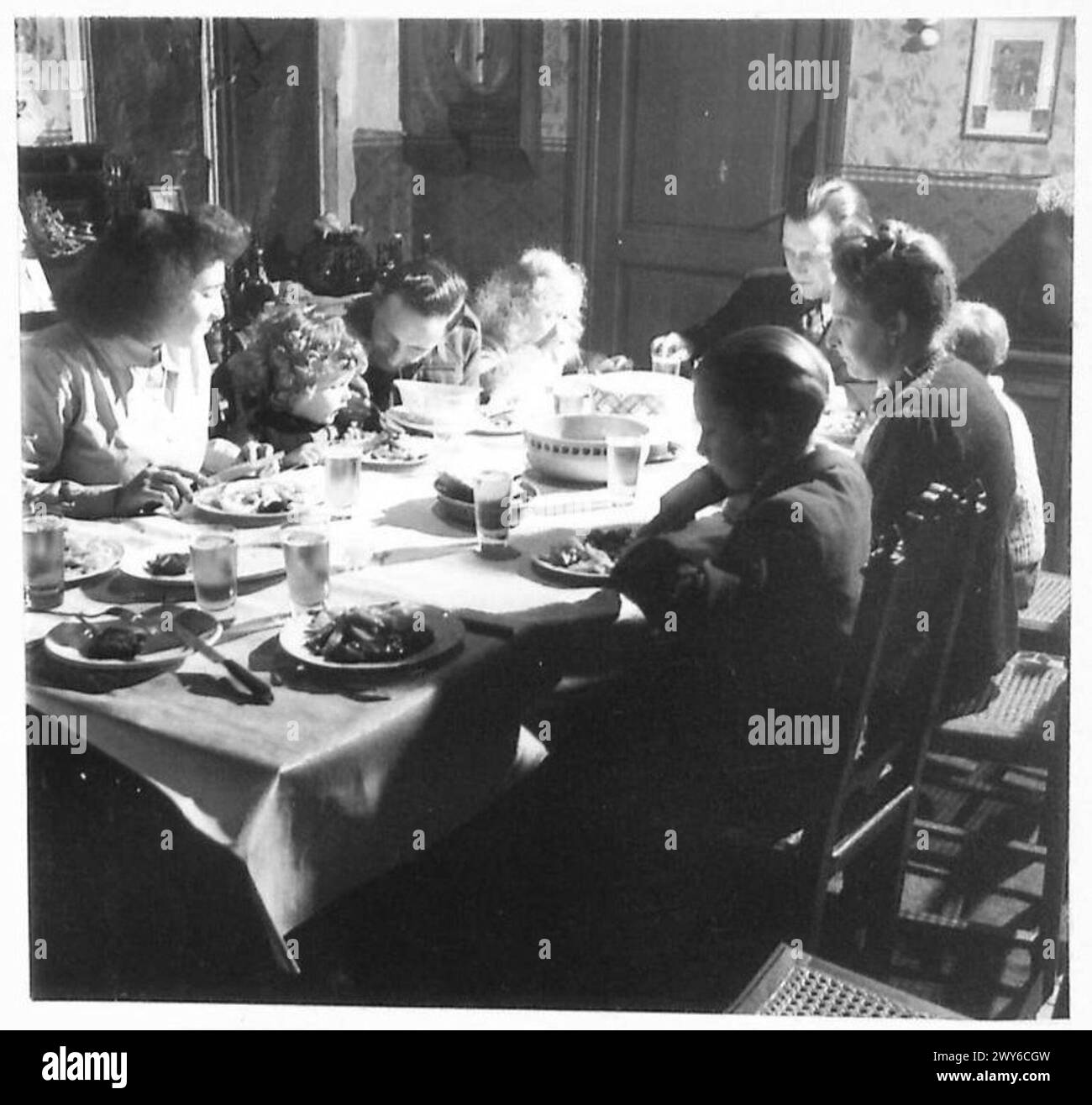 Ein britischer Soldat teilt sich Rationen mit einer lokalen Familie und demonstriert damit Kooperation und Wohlwollen. Britische Armee, 21. Armeegruppe anwesend. Stockfoto