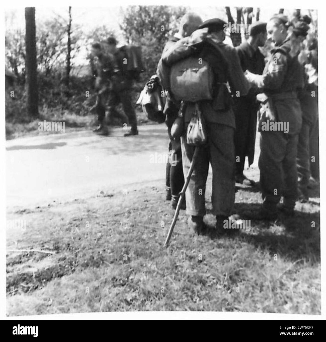Ein Offizier des Sicherheitsdienstes verhört Deutsche auf Straßen und verhaftet Personen mit falschen Papieren, während sie unter Aufsicht der britischen Armee 21st Army nach einem feindlichen Beamten suchen. Stockfoto