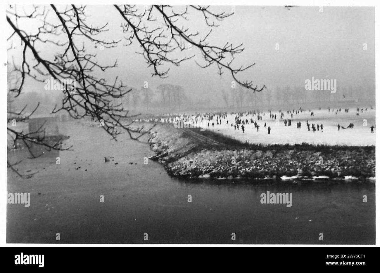 Soldaten und Zivilisten laufen auf einem gefrorenen Graben und nutzen die malerische Lage als Erholungsgebiet im Winter, British Army, 21st Army Group. Stockfoto