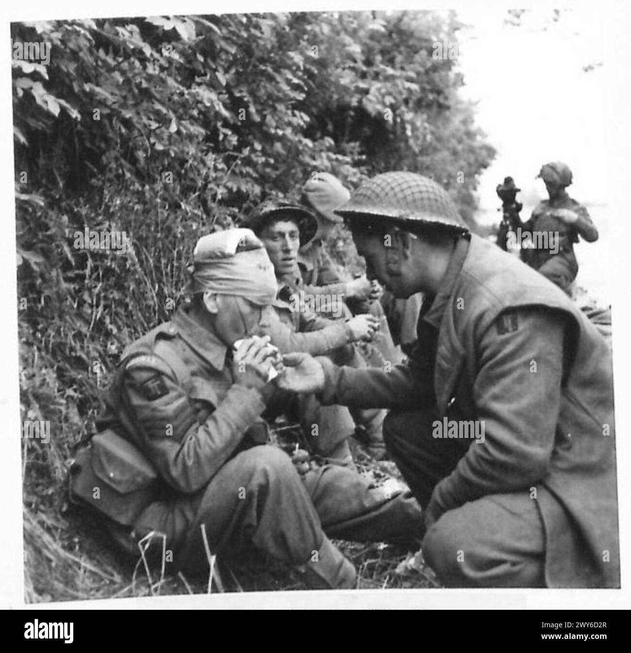 Sergeant Trevor Ingram of Nantwich, 6. Durham leichte Infanterie, 151. Brigade, verwundet in der Schlacht bei Lingevres, hat eine Zigarette, nachdem seine Wunde beim Regimental Aid Post der 50. Division verbündet wurde. Britische Armee, 21. Armeegruppe Stockfoto