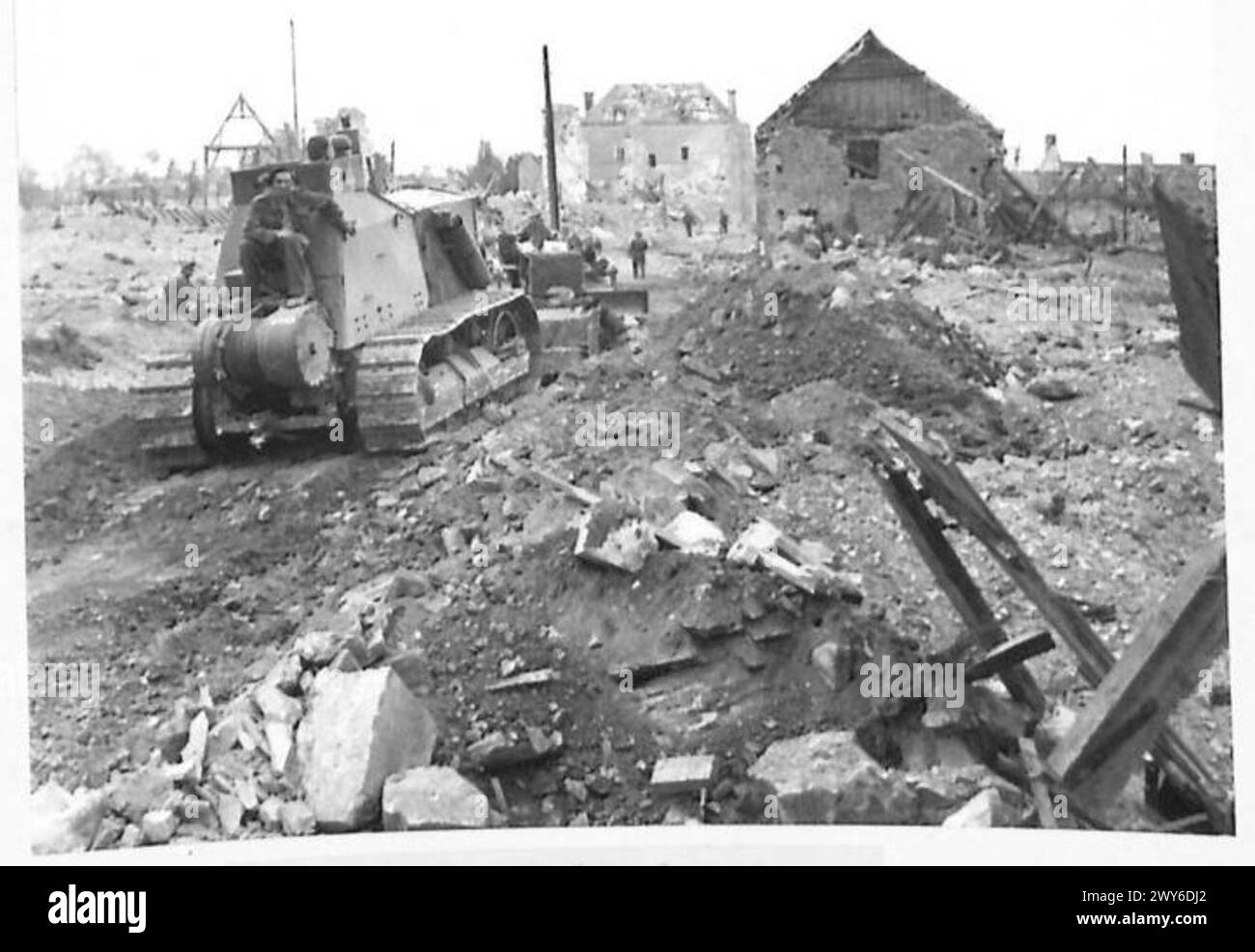 VILLERS BOCAGE WURDE VON BRITEN EROBERT - Ein Bulldozer, der Straßen in der Stadt ebnet, die von Ruinen blockiert wurden. Britische Armee, 21. Armeegruppe Stockfoto