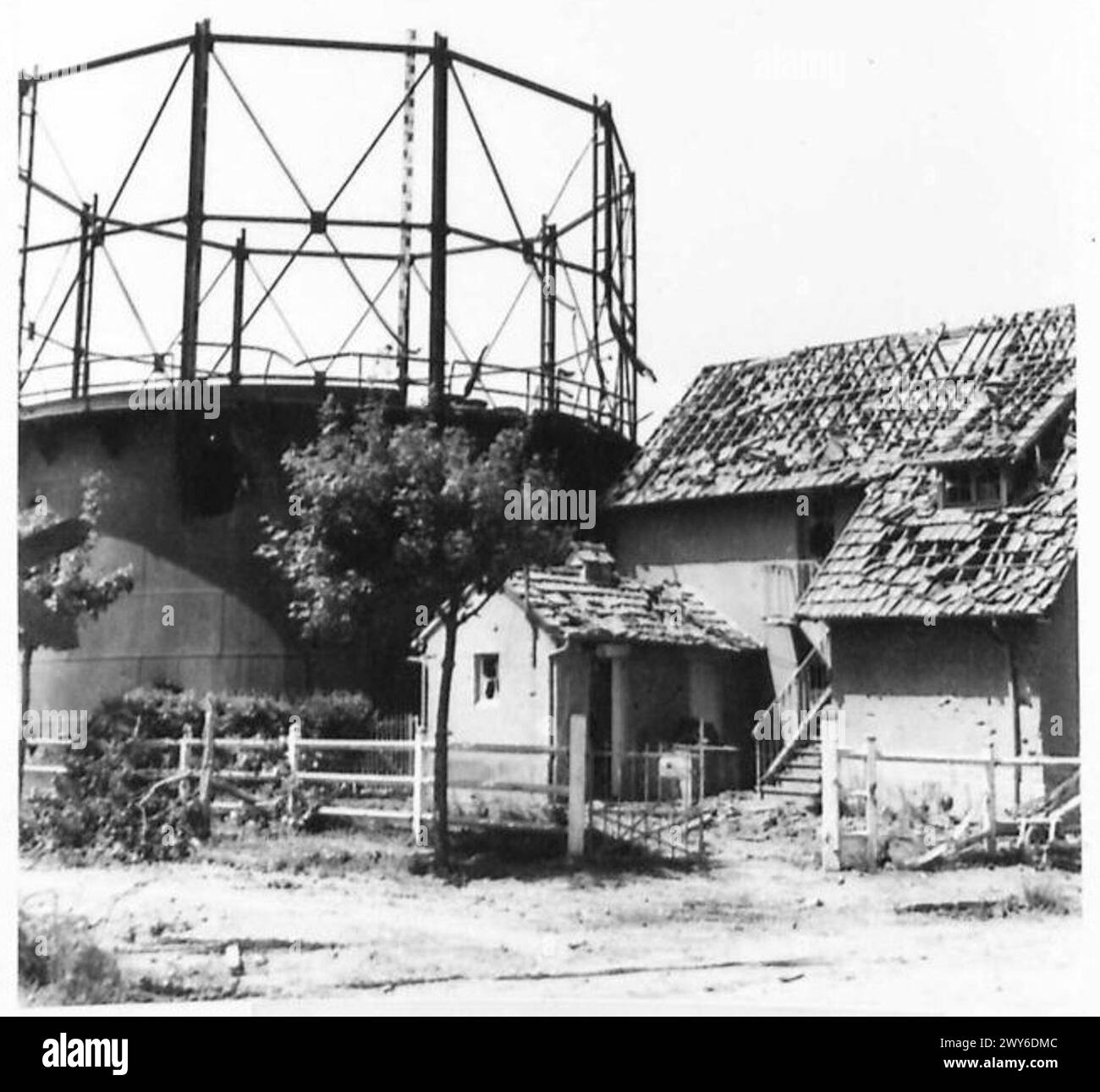 DIE BRITISCHE ARMEE IN NORDWESTEUROPA 1944-1945 - die Panzerung beschädigte das Gaswerk in Lion Dur Mer. Dieser Ort war von Scharfschützen befallen, die zahlreiche Opfer verursachten. Britische Armee, 21. Armeegruppe Stockfoto