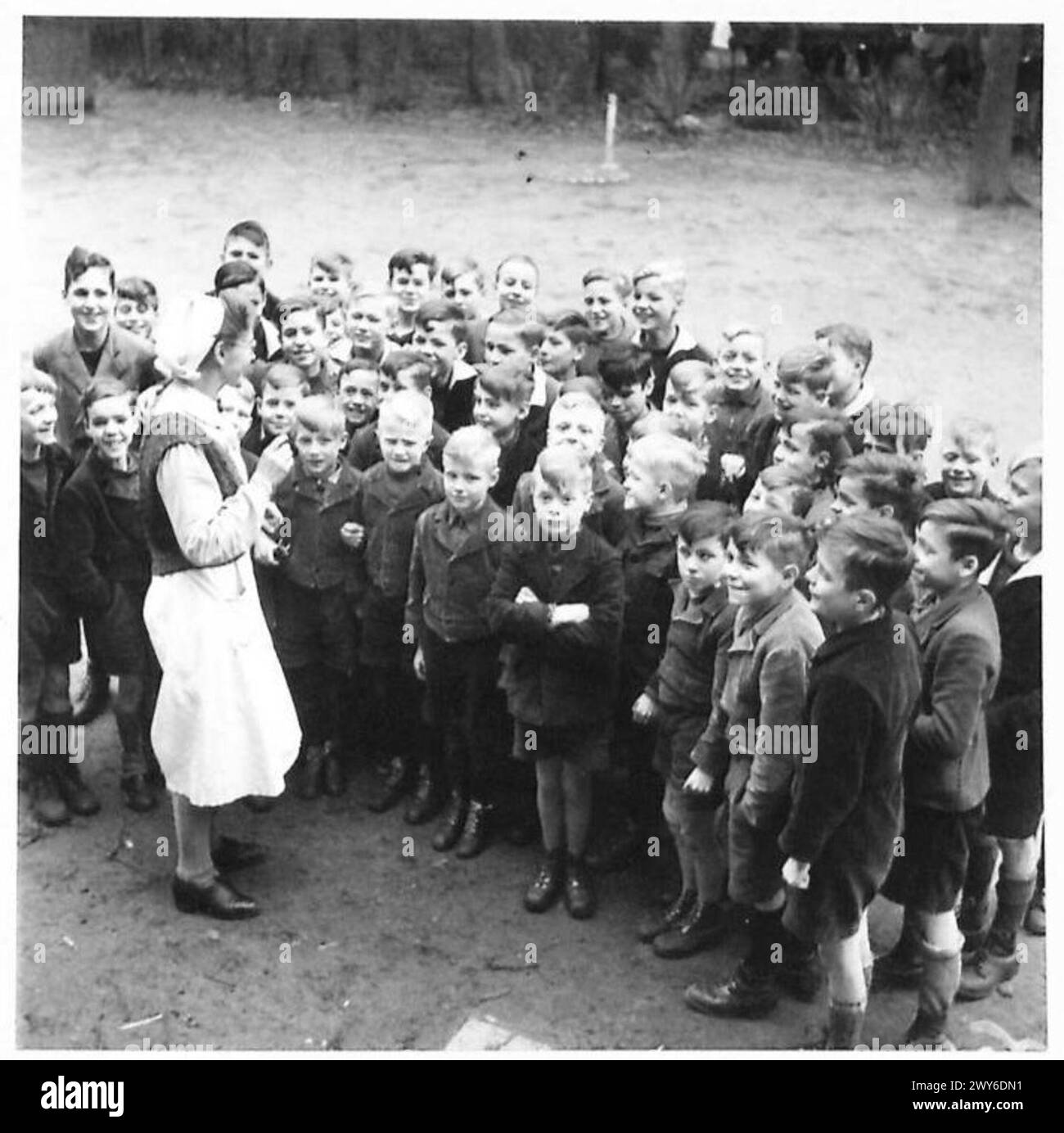 Deutsche Kinder interagieren während des Zweiten Weltkriegs mit Soldaten der Alliierten unter Militärregierung und zeigen Neugier und Bereitschaft, sich zu engagieren. Stockfoto