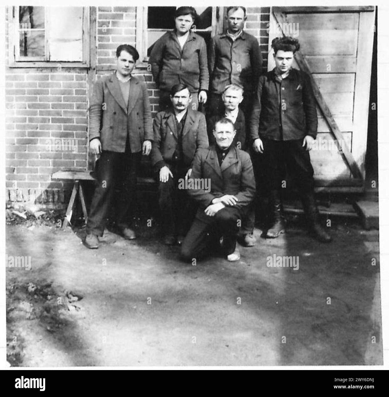 Sieben russische Kriegsgefangene werden nach ihrer Befreiung durch britische Truppen der 21. Armeegruppe während des Zweiten Weltkriegs gezeigt. Das Bild fängt den Moment ihrer Freilassung ein und markiert eine bedeutende humanitäre Anstrengung während des Konflikts. Stockfoto