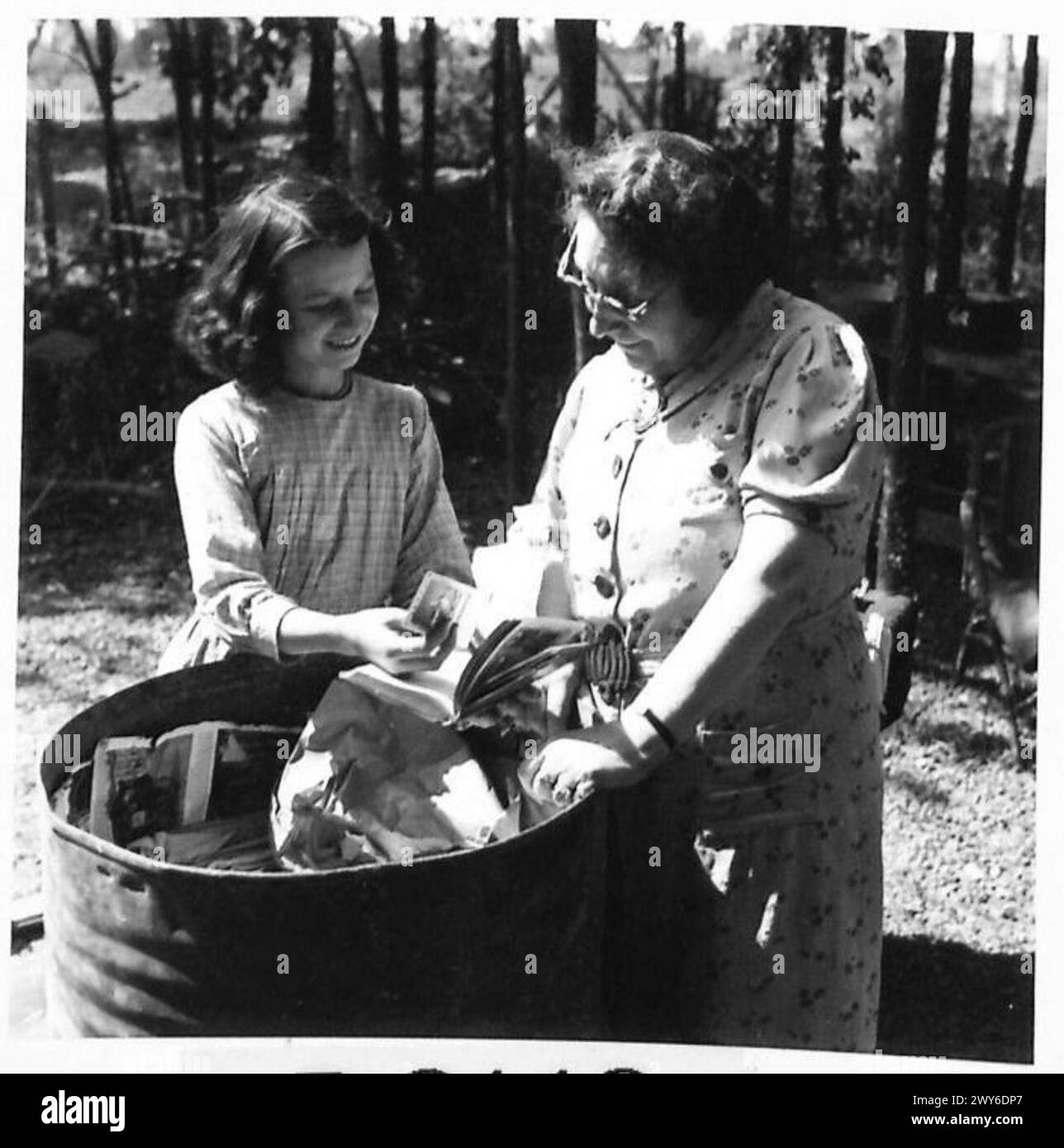Mme. Meybon inspiziert Haushaltsgegenstände, während eine französische Familie nach ihrer Rückkehr Wertsachen zurückholt, dokumentiert von der britischen Armee, 21st Army Group. Stockfoto