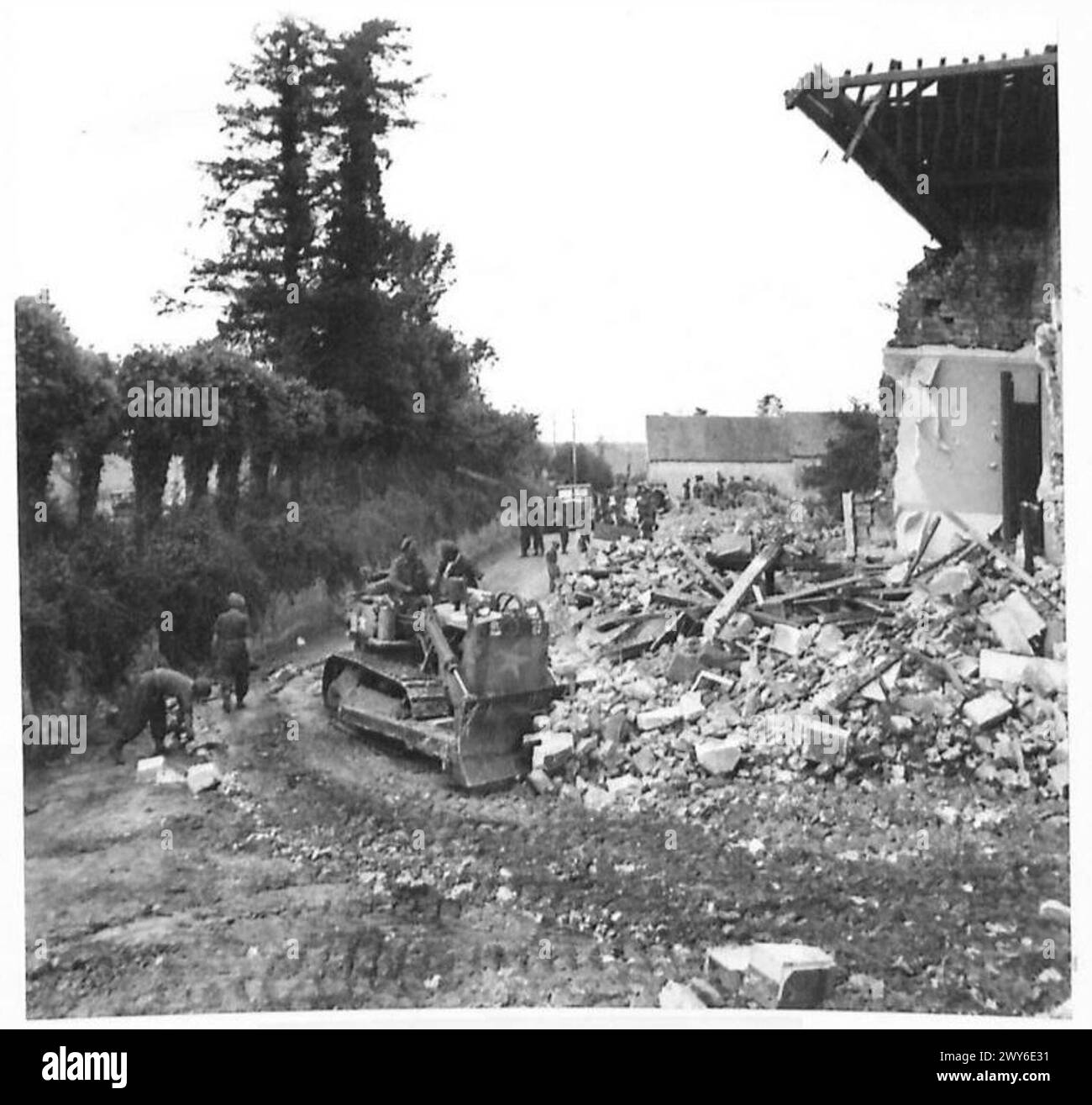BULLDOZER BESEITIGEN HINDERNISSE – der Bulldozer stürzt als Nächstes in das Gebäude, um die Reste der noch stehenden Wände niederzuschlagen und die Trümmer dann zu entfernen. Britische Armee, 21. Armeegruppe Stockfoto