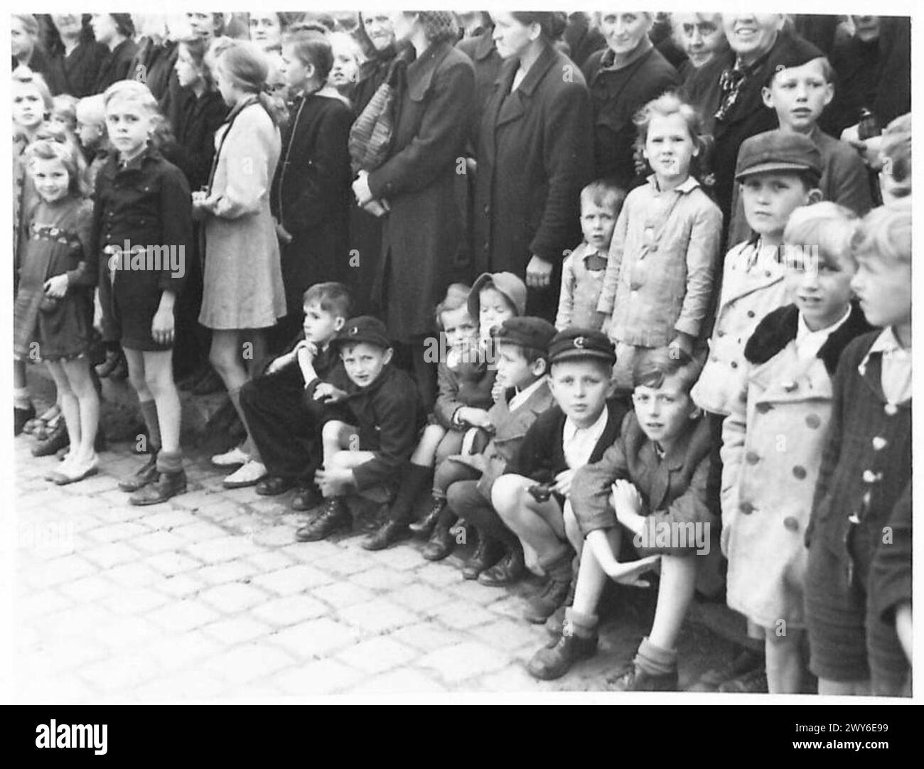 Britische Armeeeinheiten der 21. Armeegruppe betreten Berlin, während Menschenmassen ihre Ankunft während der Besatzungszeit beobachten. Stockfoto