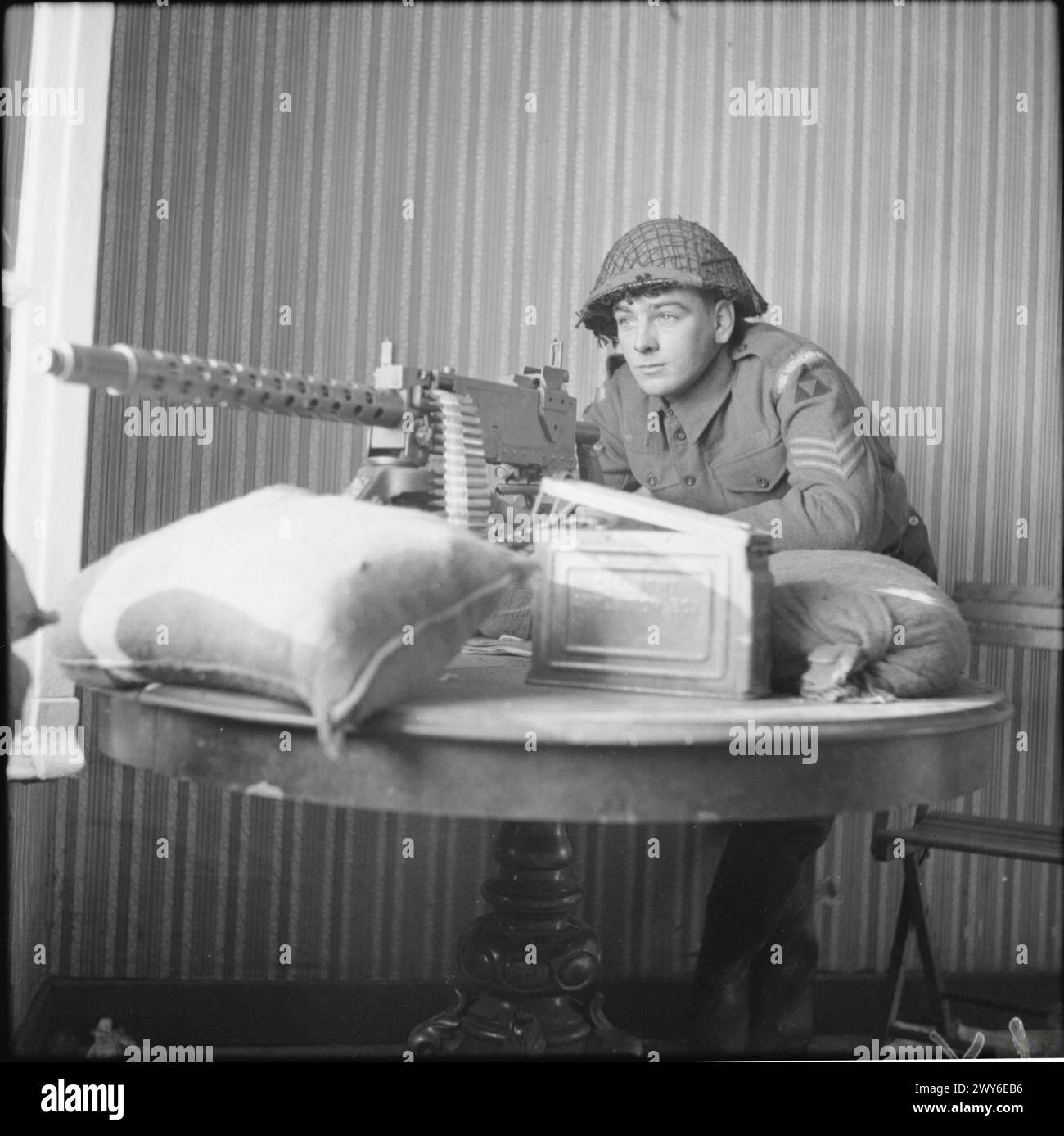 Sgt Mobley vom 2. Warwickshire-Regiment, 185. Brigade, 3. Division, besetzte ein 30-Zoll-Maschinengewehr an einem vorderen Beobachtungsposten, 22. Januar 1945, Nordwesteuropa. Stockfoto