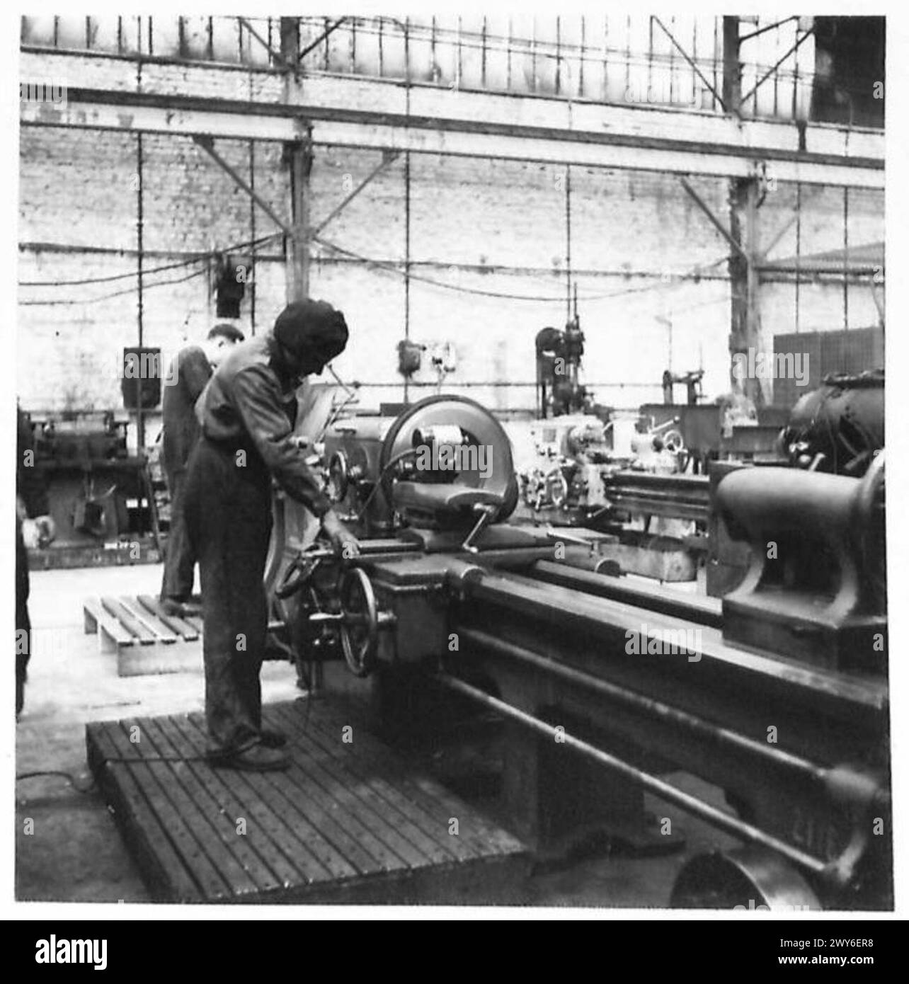 In modernen britischen Werkstätten schleift das Personal Schwungradflächen mit Drehmaschinen mit Werkzeugpfeilschleifmaschinen nach. Stockfoto