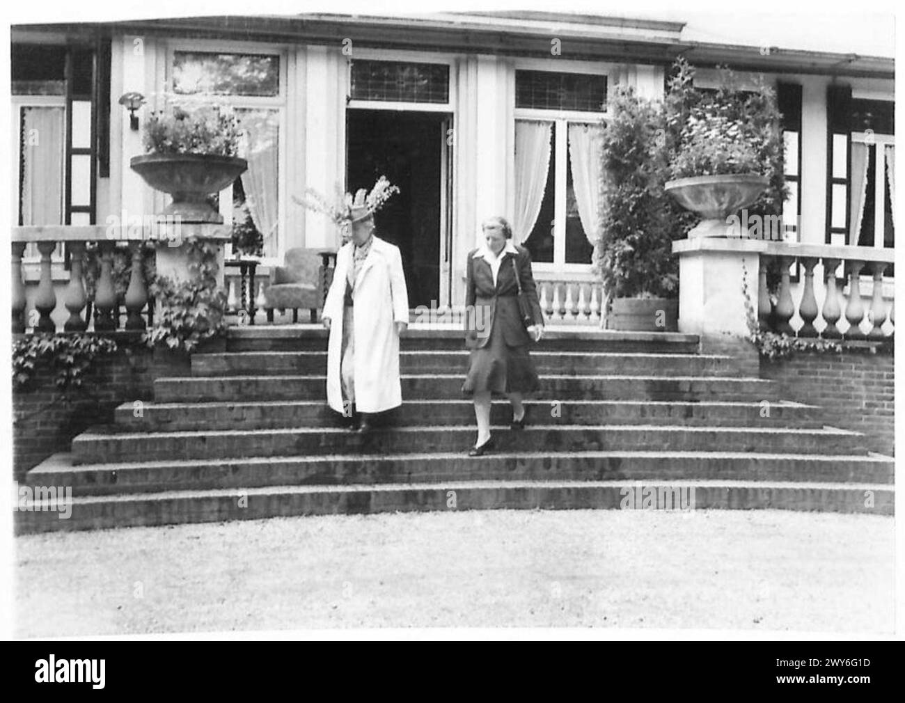 Das Foto zeigt Königin Wilhelmina und Prinzessin Juliana von den Niederlanden, die ein Haus für einen Spaziergang auf dem Gelände in der Nähe von Anneville, Breda, Holland verlassen. Stockfoto