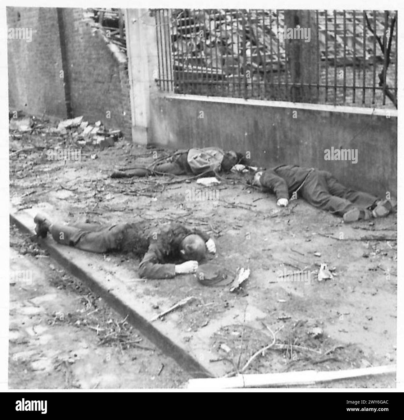 Drei deutsche Soldaten liegen während des Vormarsches der britischen Armee in der Nähe einer Kirche in Bocholt tot. Stockfoto