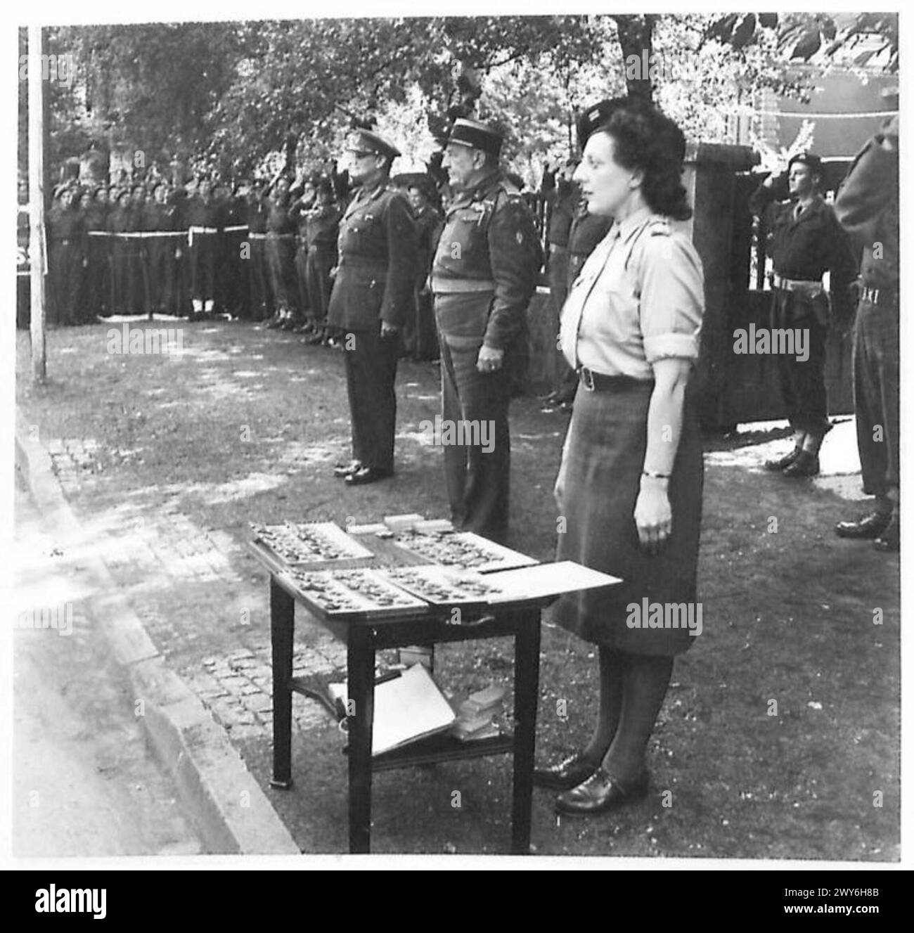 EINSETZUNG : PRÄSENTATION DES GUERRE CROIX PE AN OFFIZIERE UND MÄNNER DER 49. DIVISION - Colonel Lanu grüßt während des Spiels der französischen Nationalhymne. Britische Armee, 21. Armeegruppe Stockfoto