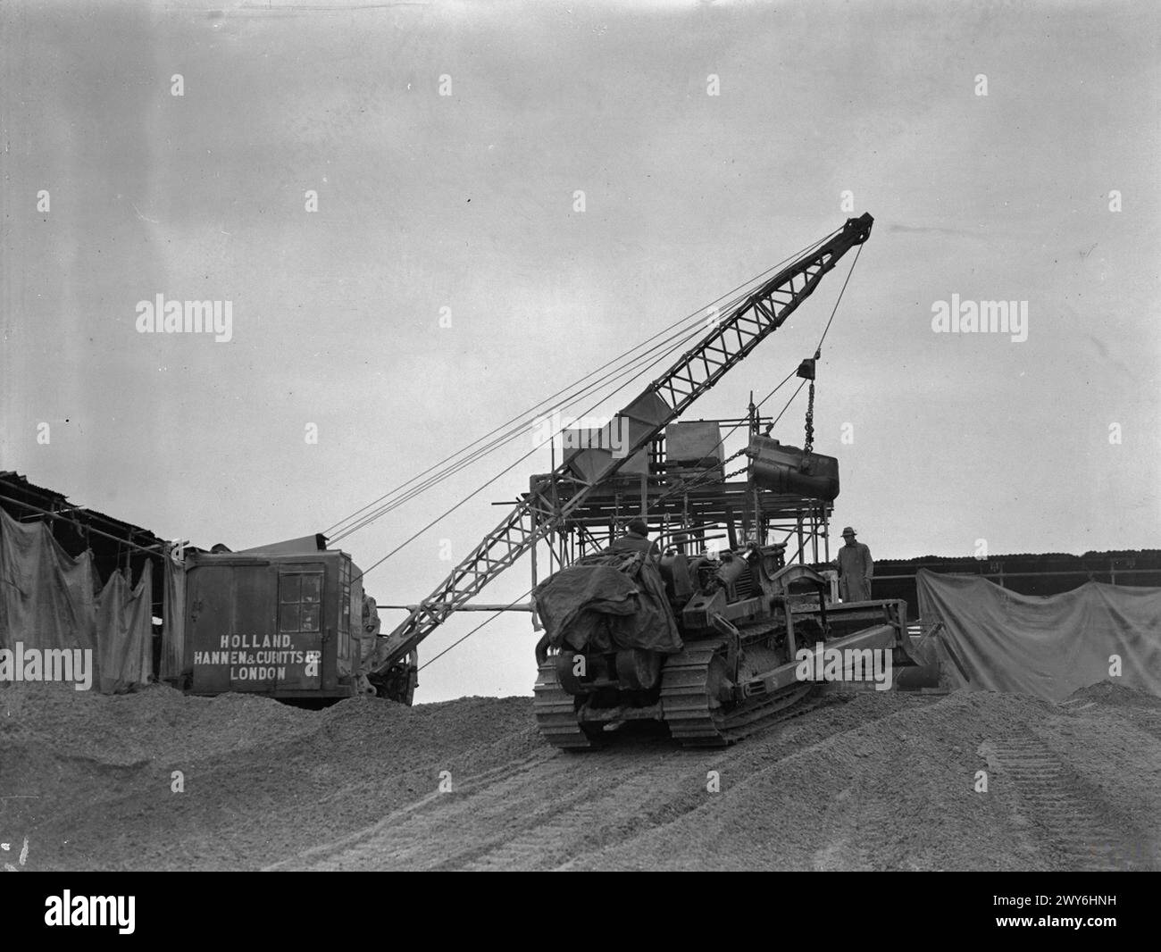 Ein Bulldozer und ein Ruston Bucyrus Dragline-Bagger Nr. 10 arbeiten an einem Kieshaufen während des Baus des Flugplatzes Nr. 3 der Gruppe RAF in Witchford, Cambridgeshire, 1942–1945. Stockfoto