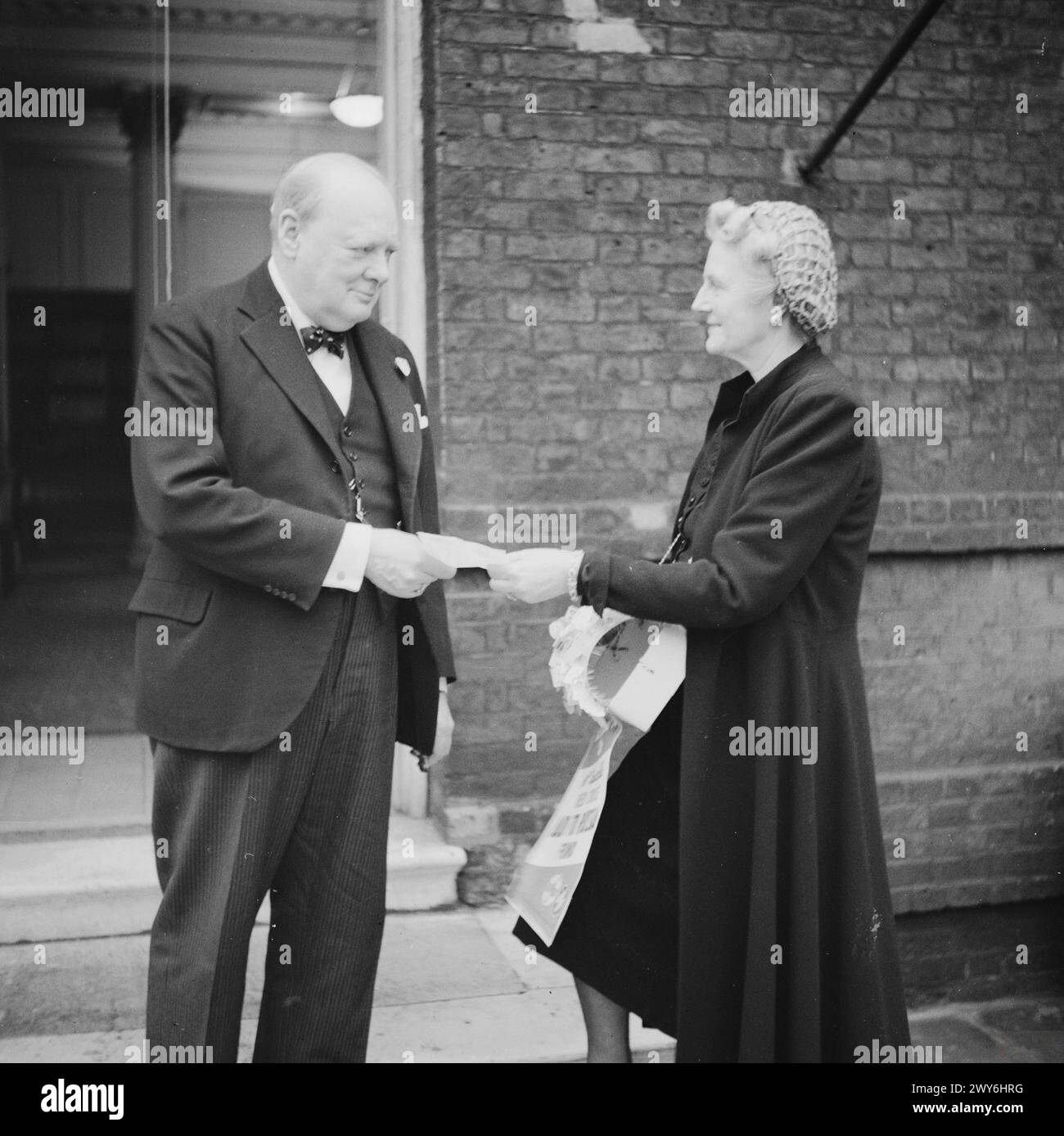 Premierminister Winston Churchill erhält am 9. Dezember 1941 von seiner Frau Clementine die Flagge des britischen Roten Kreuzes „Aid to Russia“ Stockfoto