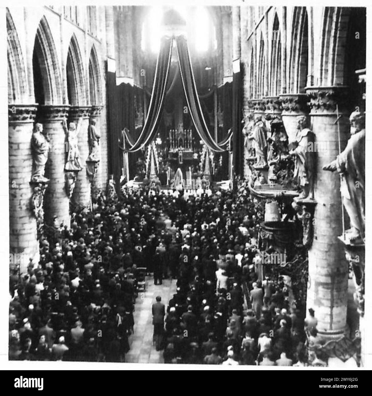 Im Inneren der Brüsseler Kathedrale nehmen Menschenmassen an der zeremoniellen Beerdigung der Polizisten teil, die während der Besatzung von deutschen Truppen erschossen wurden. Stockfoto