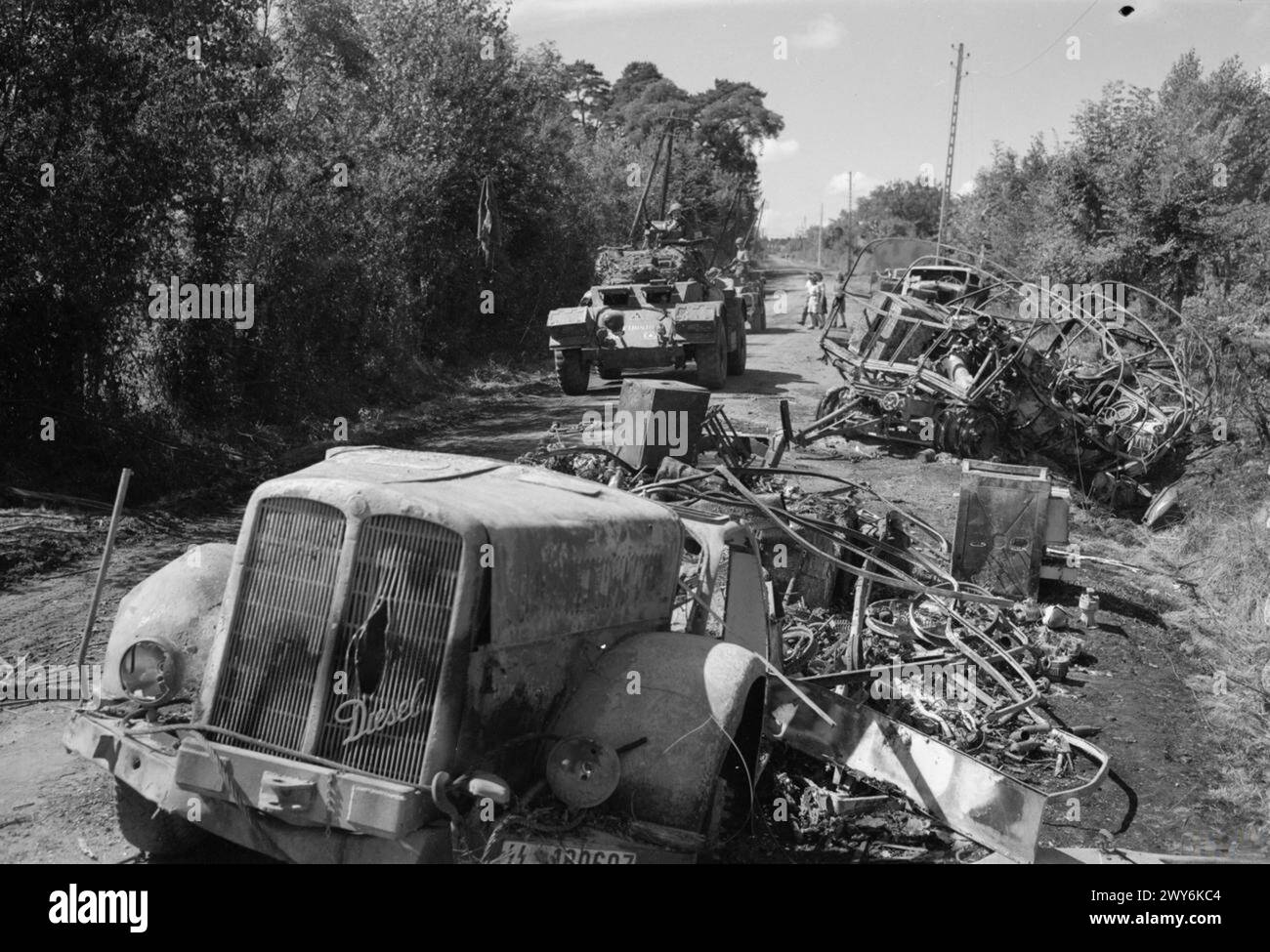 Ein Schwarzweiß-Foto, das eine Szene beschädigter Autos darstellt, die wahrscheinlich durch einen Verkehrsunfall oder durch Kriegszerstörung verursacht wurden. Das Bild zeigt die Folgen des Vorfalls und zeigt das Ausmaß der Schäden an den betroffenen Fahrzeugen. Stockfoto