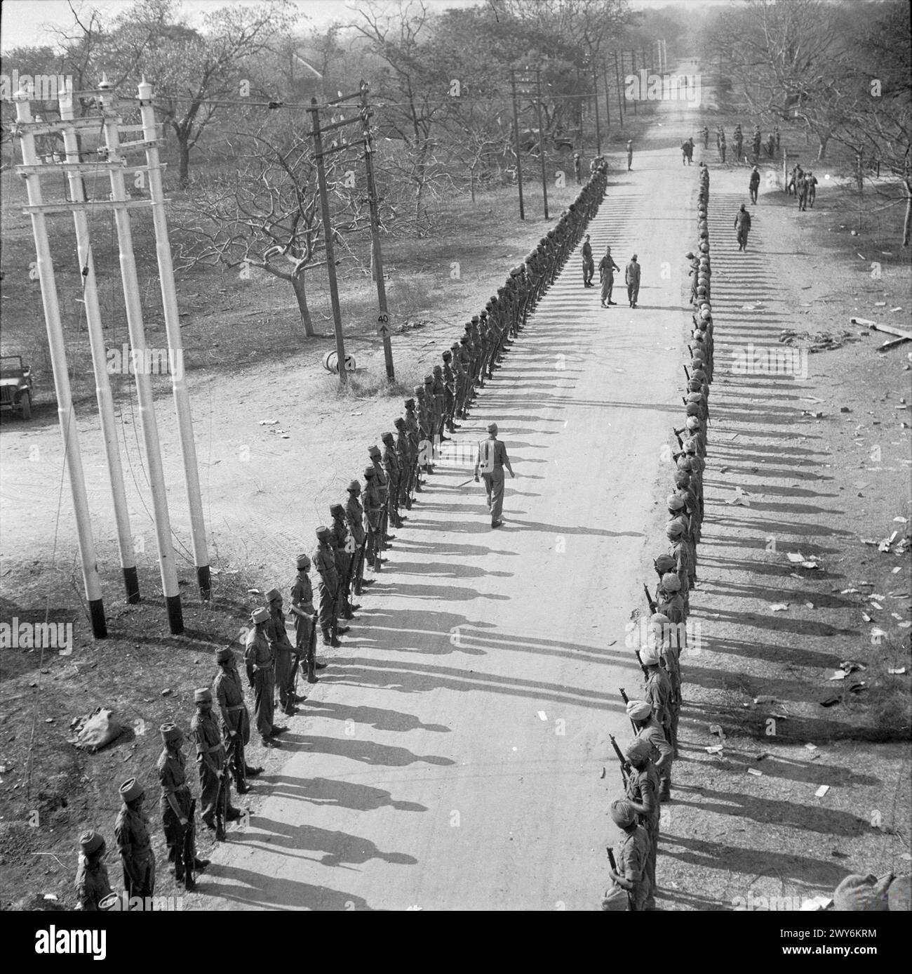 Britische und indische Truppen bilden eine Garde of Honour für General William Slim, Kommandeur der 14. Armee in der Nähe von Mandalay, nachdem sie von der 19. Indischen Division befreit wurden. Stockfoto