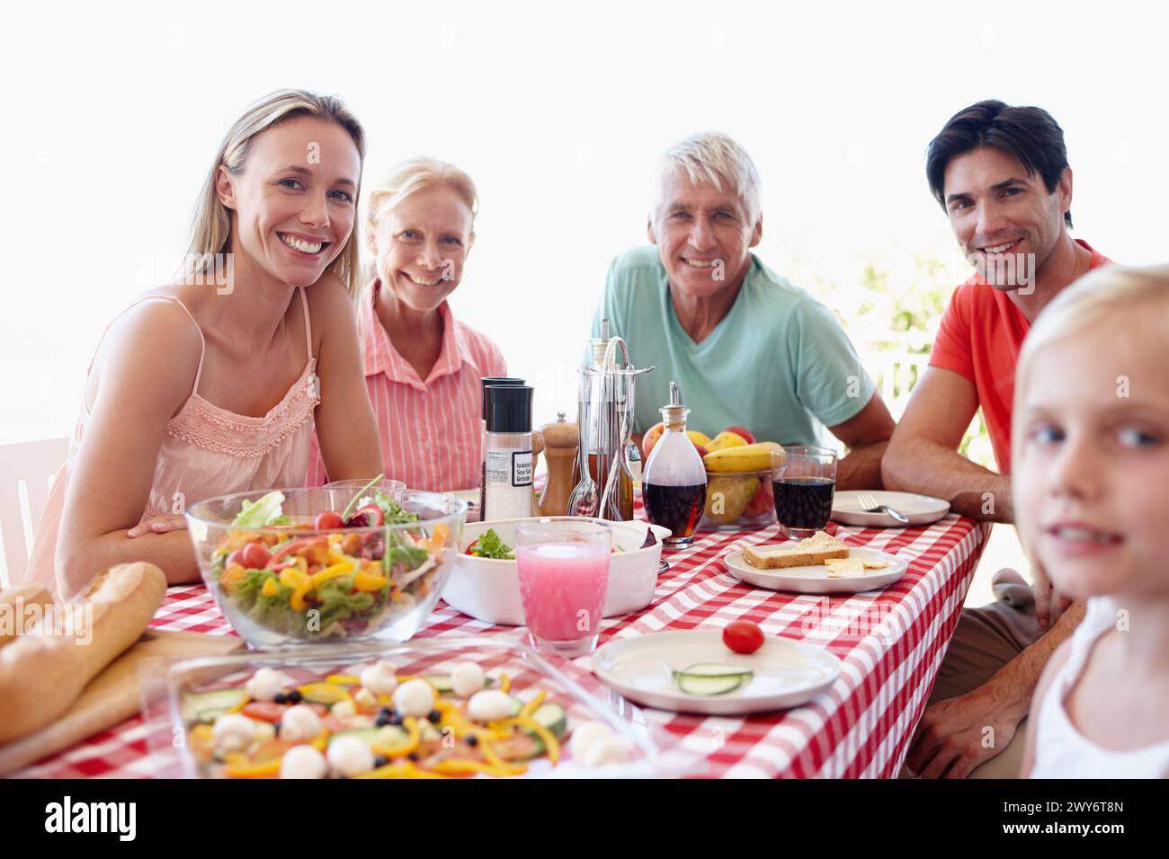 Porträt, Familie und junges Mädchen im Wohnzimmer am Tisch mit Salat, Gemüse und zusammen essen zum Mittagessen. Mom, Dad und Kind im Urlaub Stockfoto