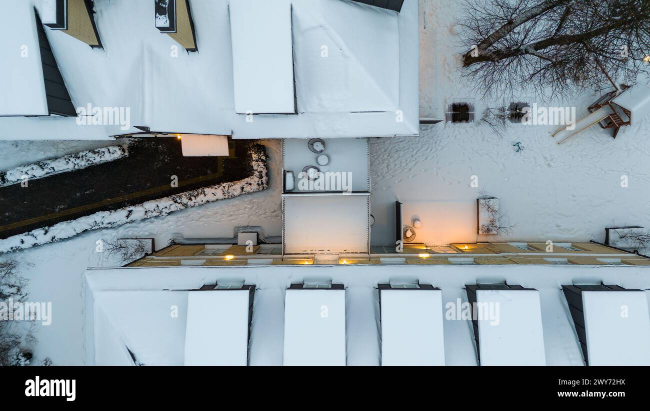 Drohnenfotografie von einer kleinen Terrasse zwischen Häusern, die während des Winters mit Schnee bedeckt sind Stockfoto