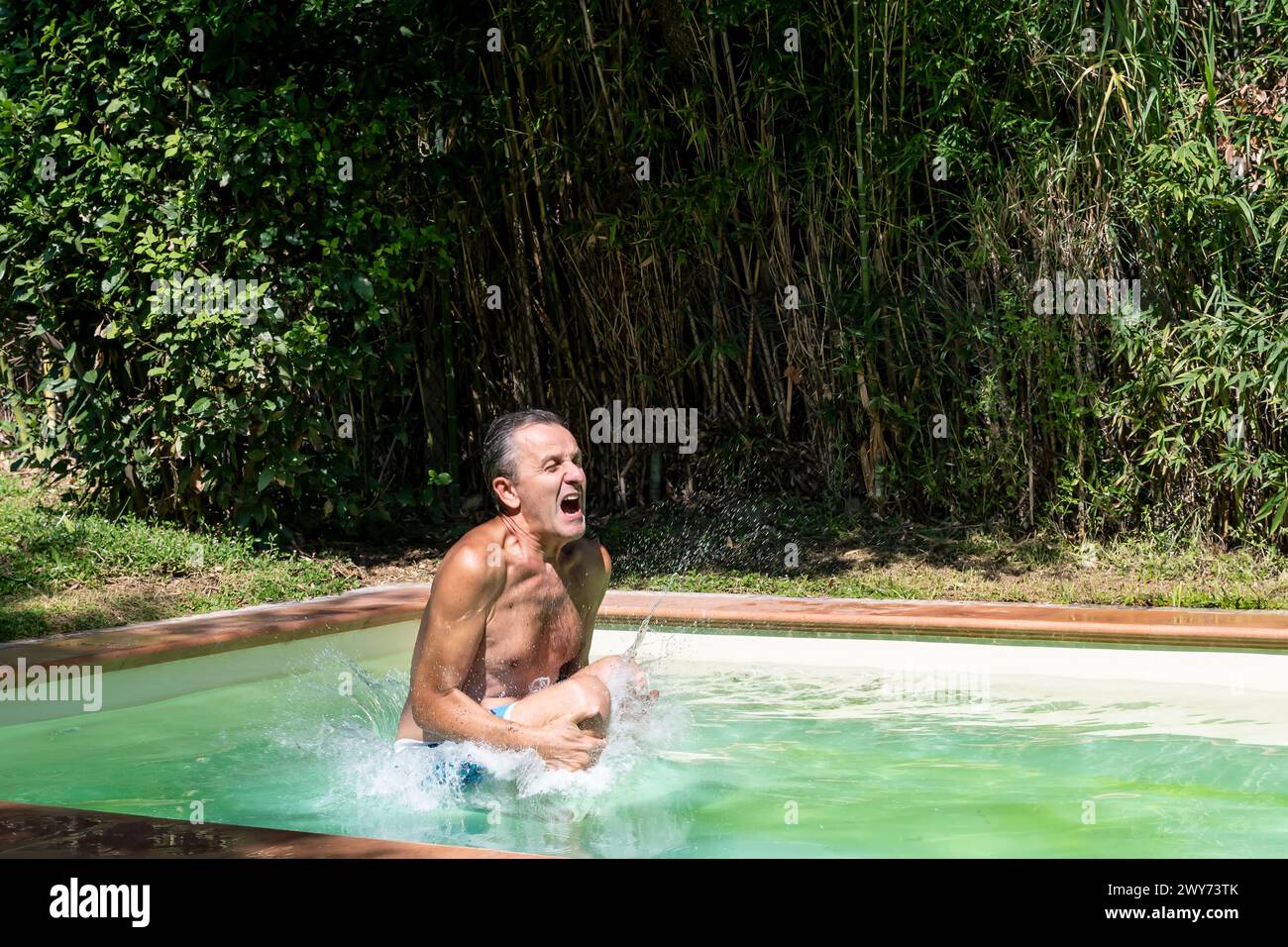 In der Sommersaison taucht ein Mann in ein Schwimmbad Stockfoto