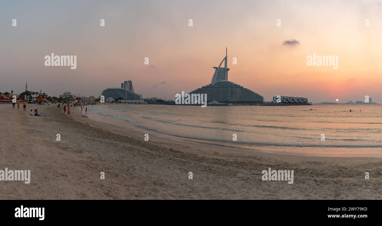 Ein Bild vom öffentlichen Strand von Jumeirah, dem Jumeirah Marsa Al Arab Hotel und dem Burj Al Arab Hotel bei Sonnenuntergang. Stockfoto