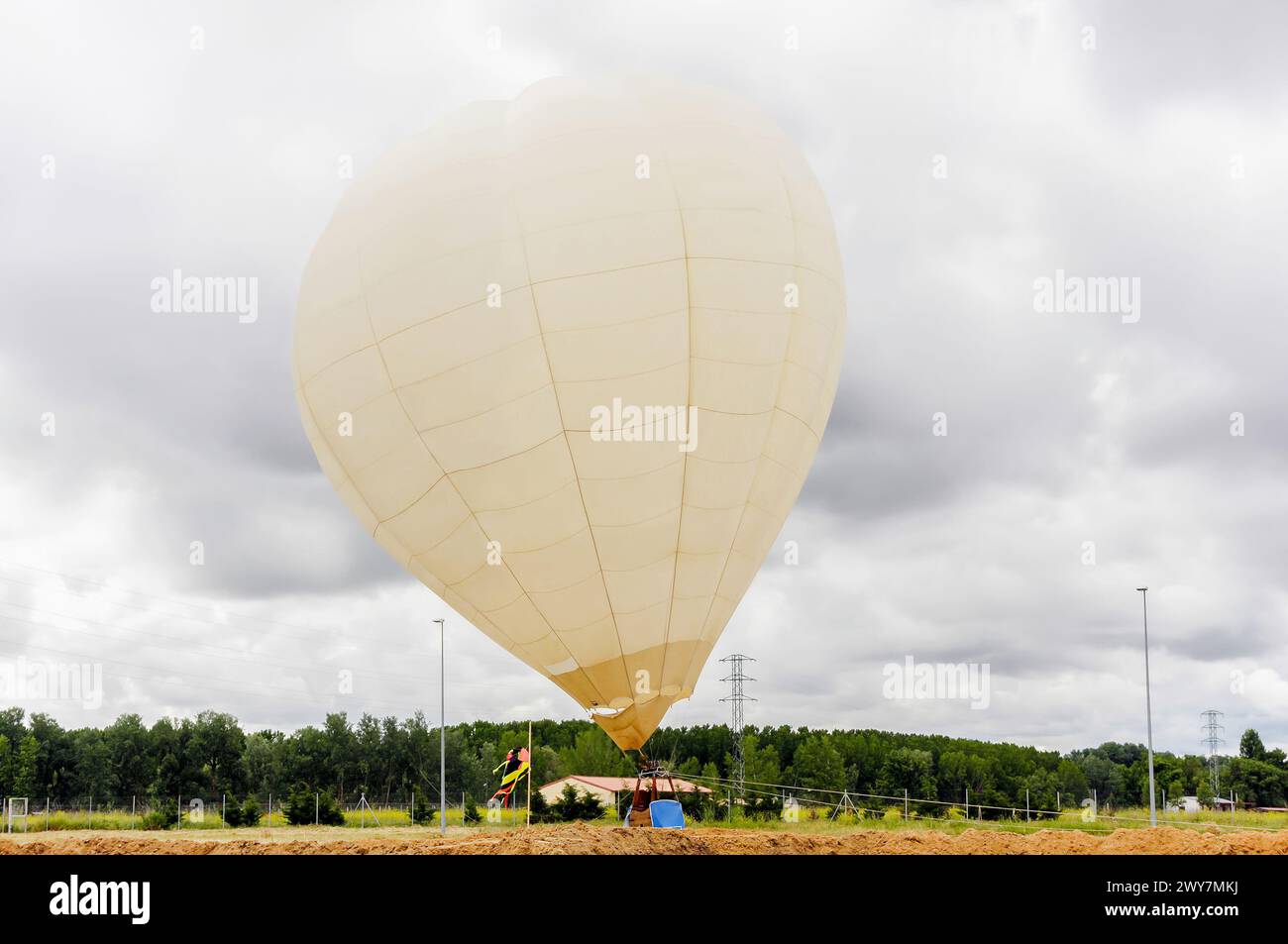 Ballon, der an einem bewölkten Tag auf einem Feld thront. Heißluftballon. Stockfoto