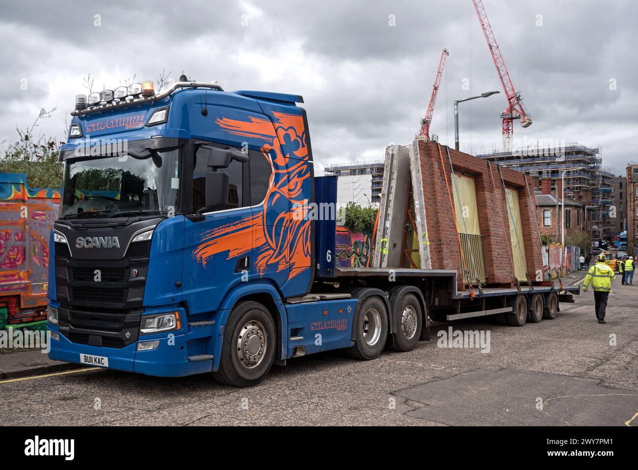 Betonfertigteile und rote Backsteinwände auf einem Anhänger, der auf einer Baustelle in Edinburgh, Schottland, Großbritannien ankommt. Stockfoto