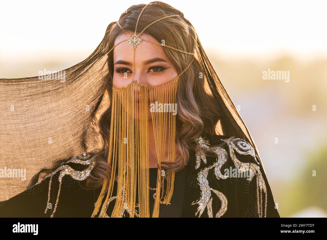 Buchara, Usbekistan, Zentralasien. August 2021. Junge usbekische Frau in traditionellem schwarzem Kleid und goldenem Schleier. Stockfoto