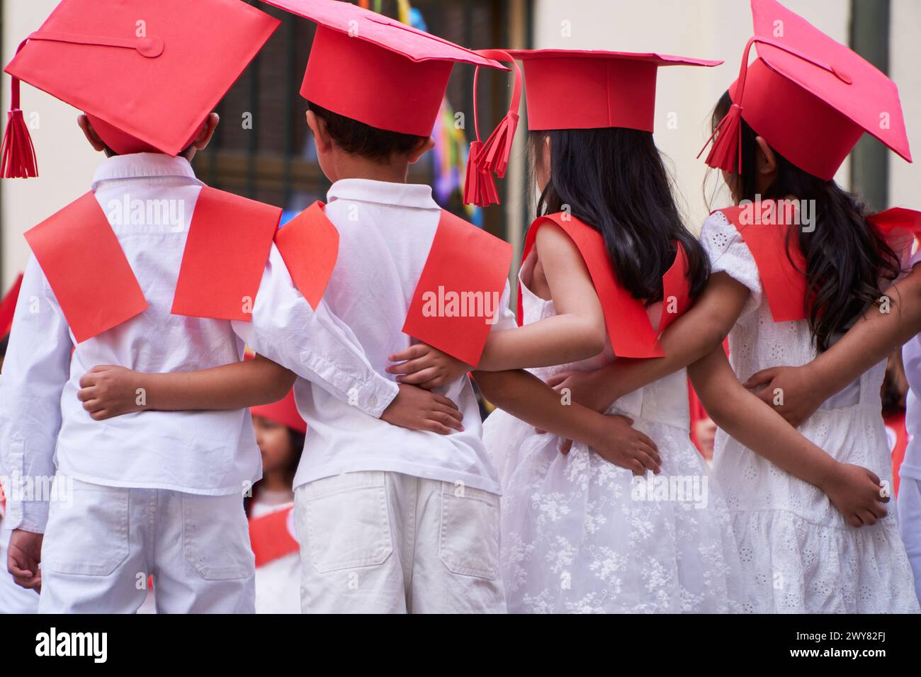 Lateinische Vorschulkinder, die sich nach ihrem Abschluss gemeinsam um die Grundschule kümmern Stockfoto