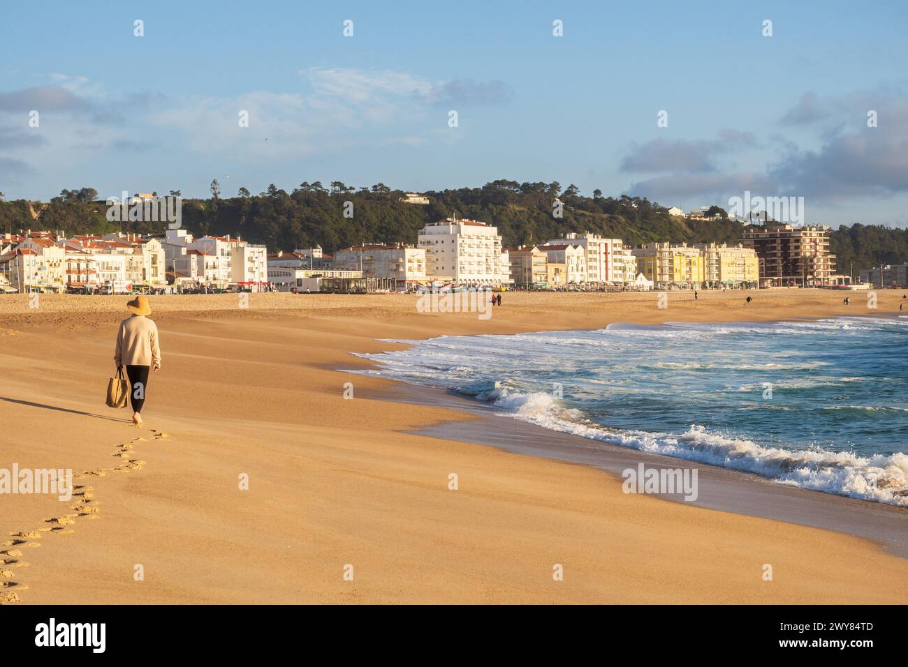 Nazaré, Portugal - 19. März 2024: Frau am Strand von Nazaré und am Atlantischen Ozean, Portugal Stockfoto