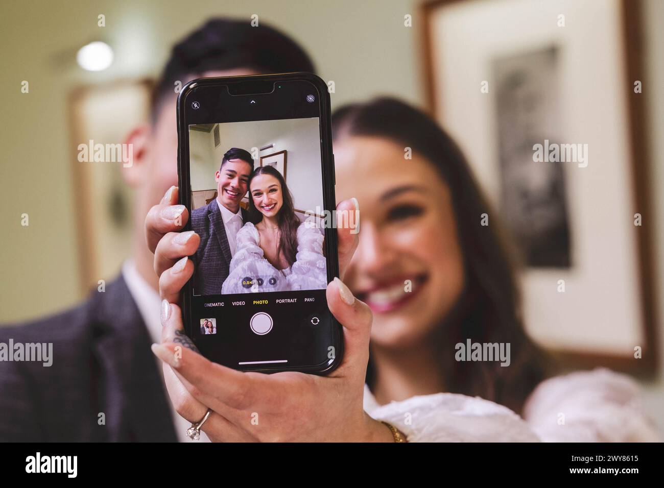 Fotograf, der frischvermählte Paare vor der Kamera festnimmt Stockfoto