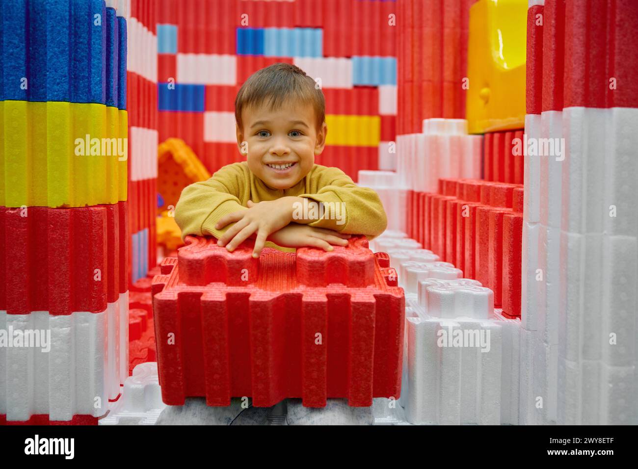 Junge Kind, das mit riesigen Bausteinen im Unterhaltungszentrum spielt Stockfoto