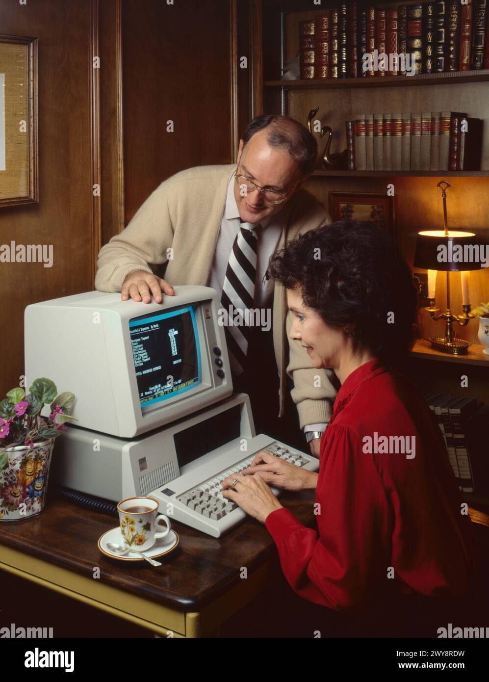 Paare am IBM 1981 Personal Computer in Heim studieren und Budget Stockfoto
