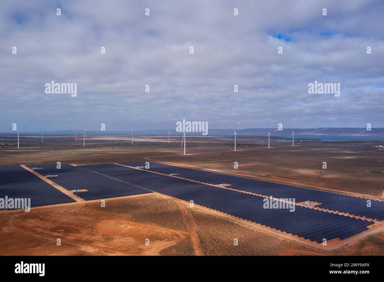 Aus der Vogelperspektive eines Stromerzeugers mit Windturbinen und Solarpaneelen in einer weiten, offenen Landschaft Stockfoto