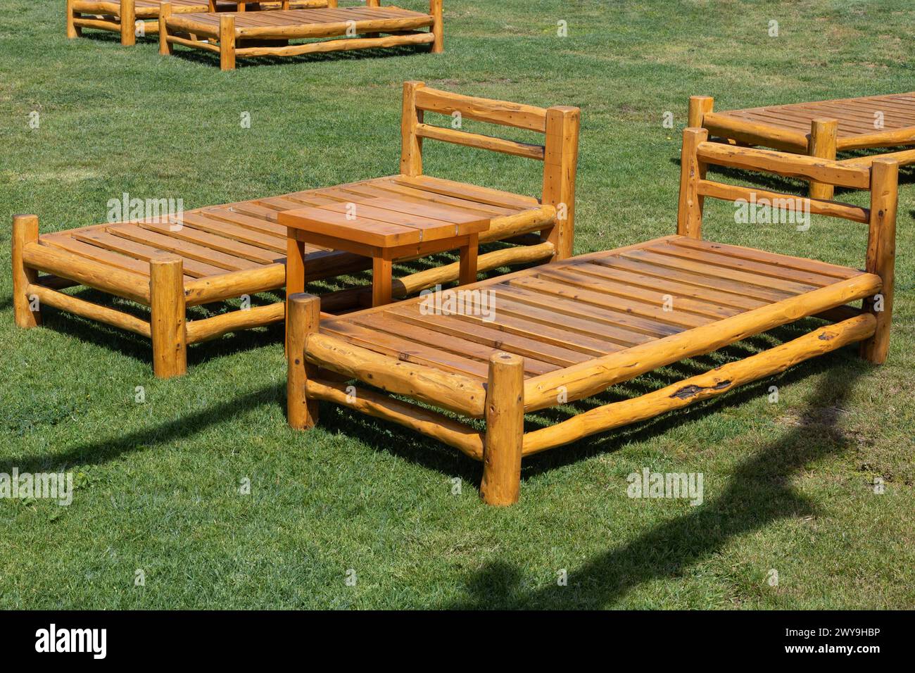 Rustikale hölzerne Gartenmöbel auf dem Rasen Stockfoto