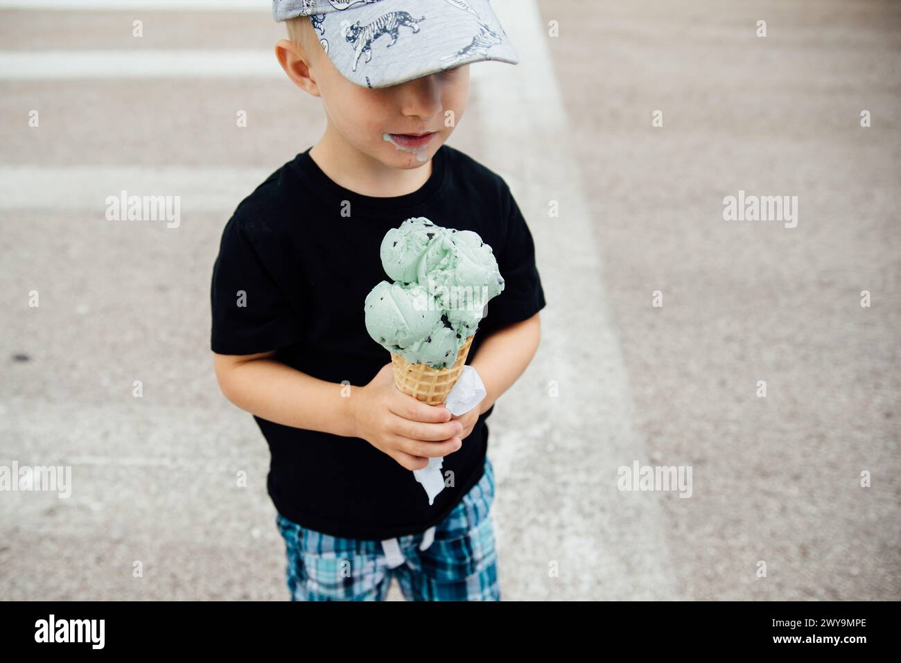 Detailansicht eines kleinen Jungen, der draußen große Eisbecher hält Stockfoto