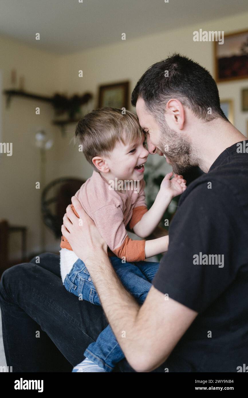 Vater und Sohn zu Hause lächeln und lachen Stockfoto