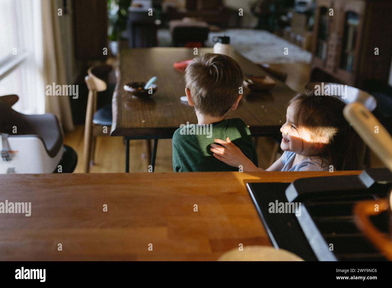 Kinder kitzeln nach dem Abendessen an einem unordentlichen Tisch Stockfoto