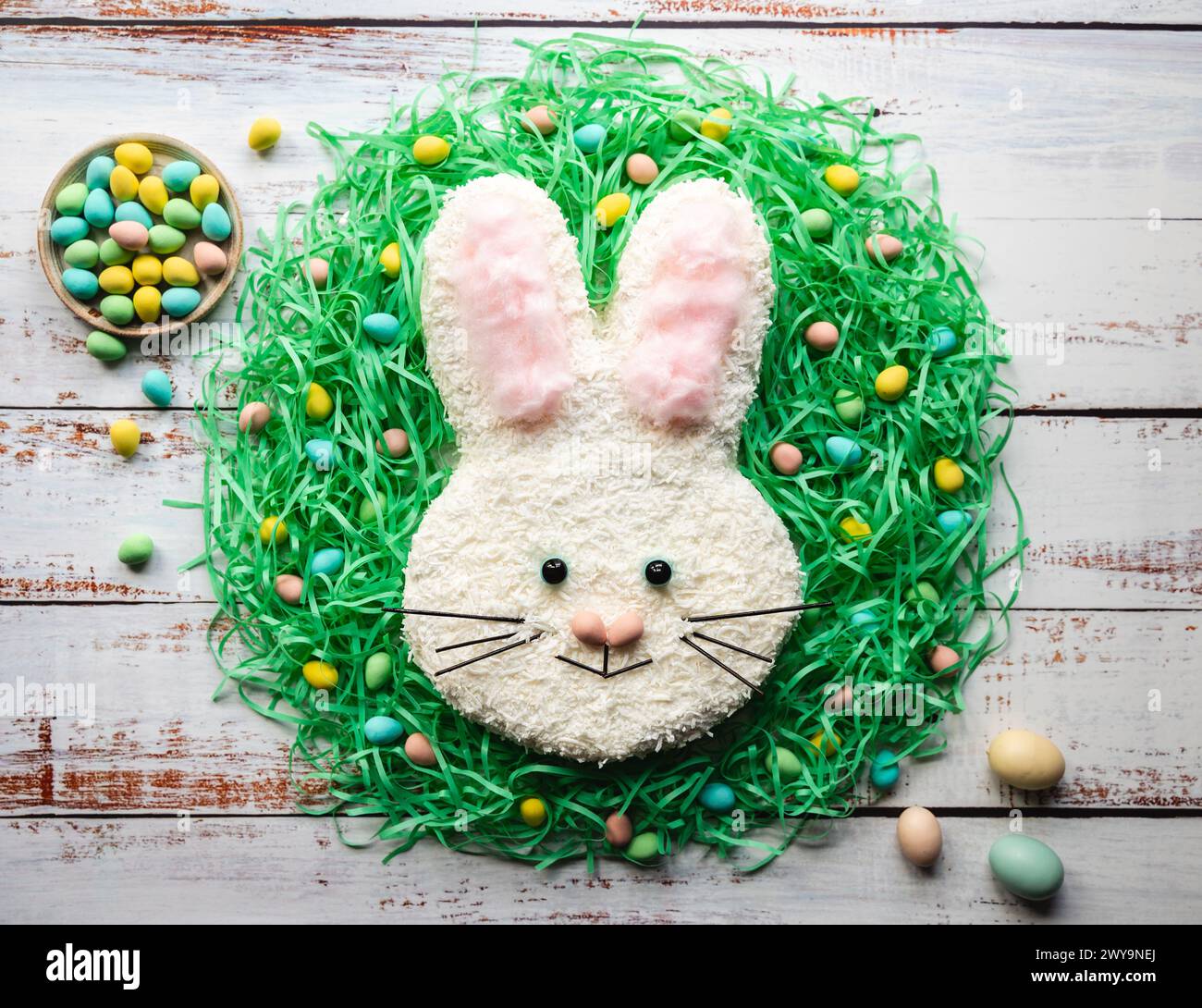 Blick von oben auf den Osterhasenkuchen auf weiß gewaschenem Holztisch. Stockfoto