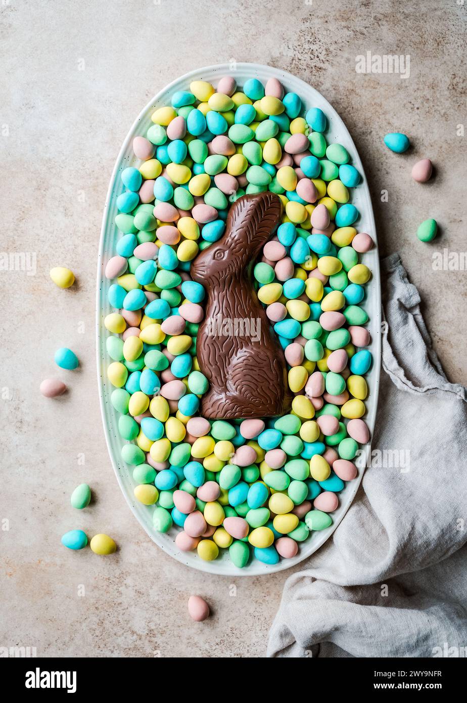 Über dem Schokohasen in einem Tablett mit Mini-Schokoladen-Ostereiern. Stockfoto